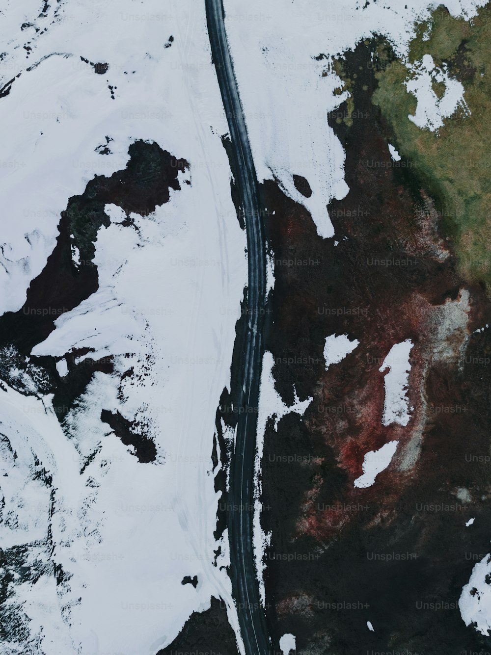 an aerial view of a road in the snow