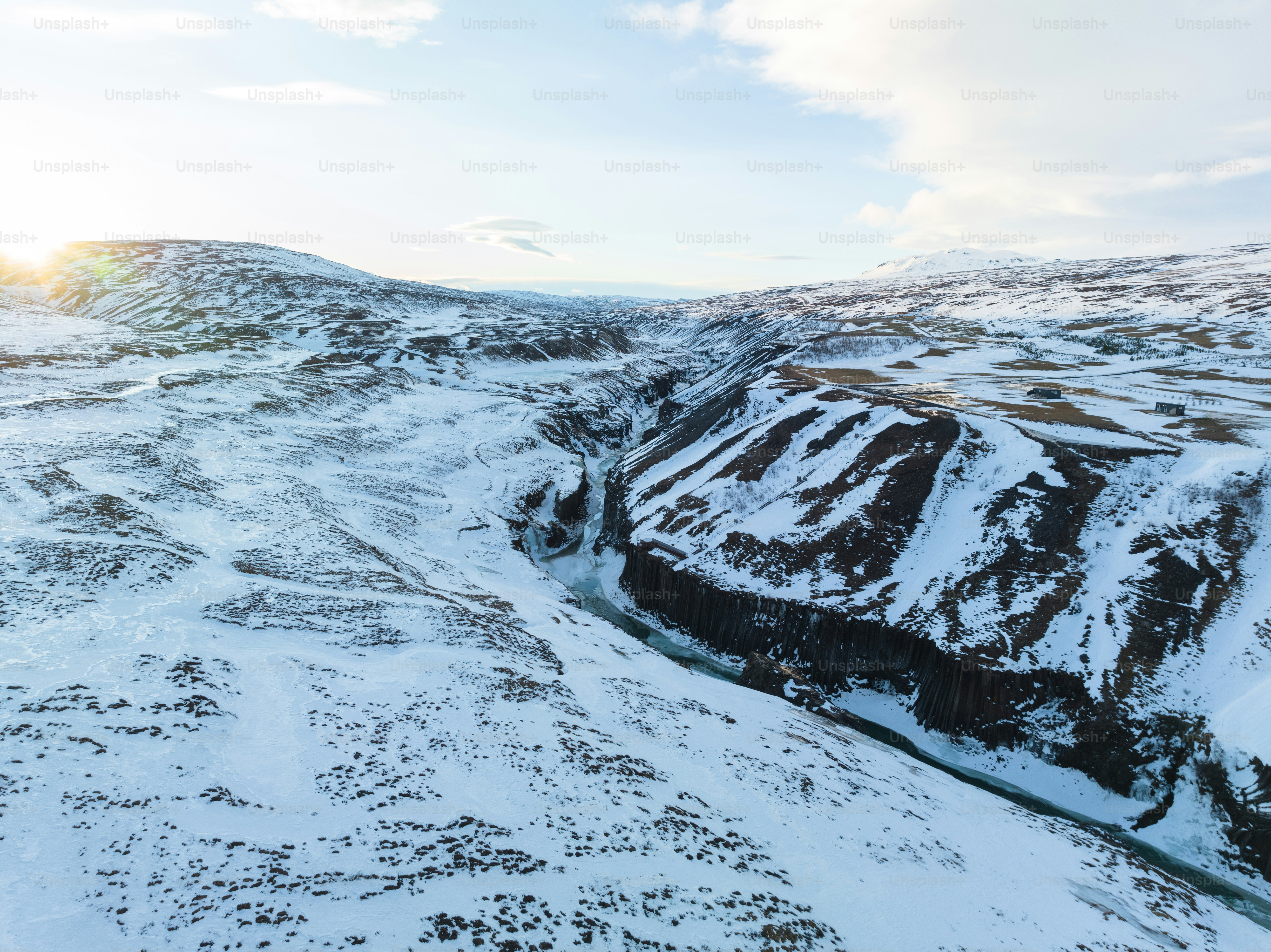 A snow covered mountain with a river running through it photo – Winter ...