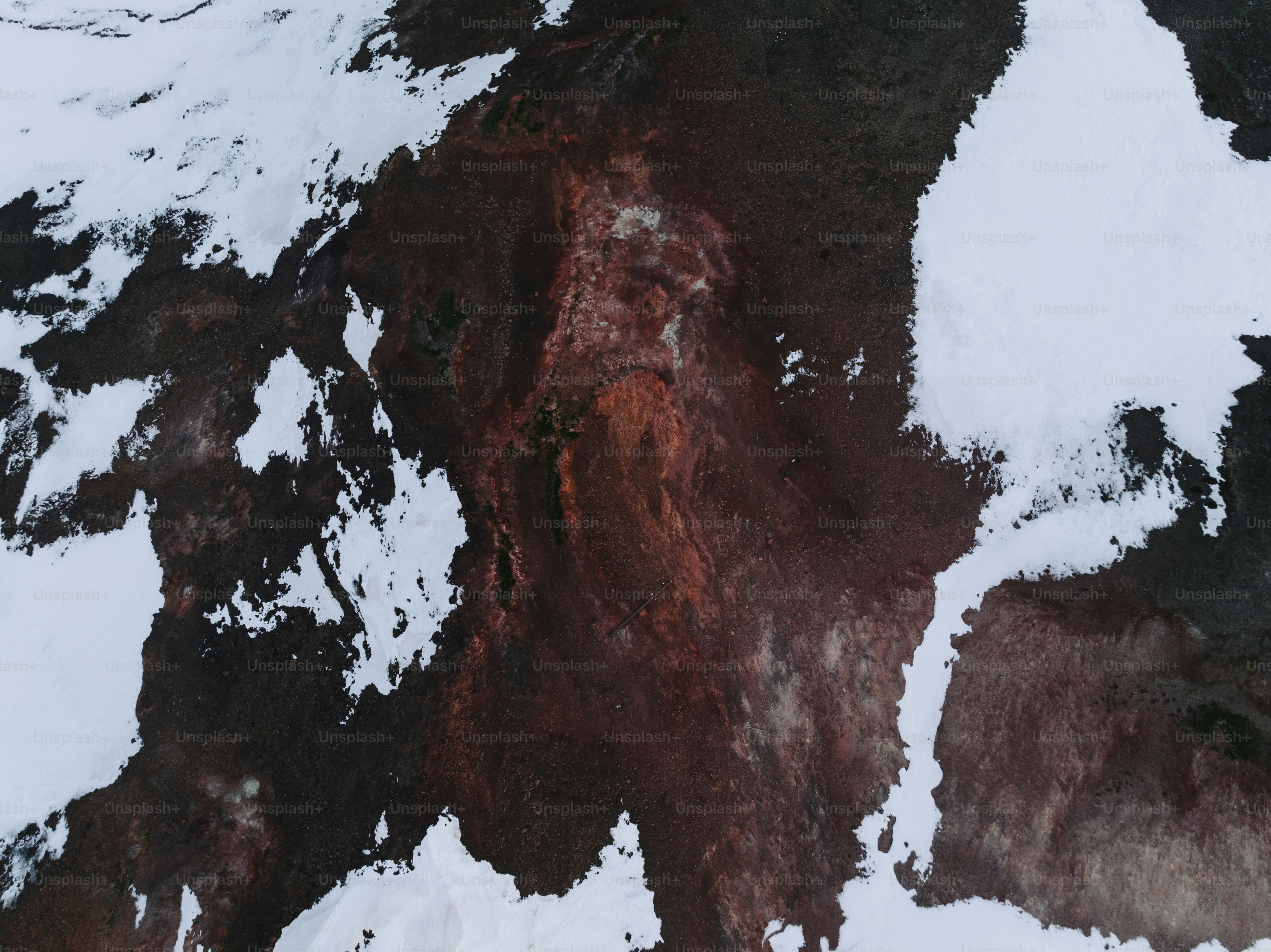 an aerial view of a mountain covered in snow