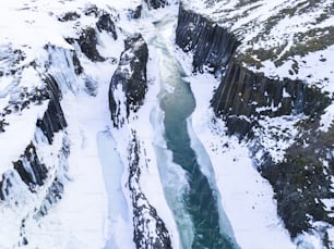 Vue aérienne d’une rivière traversant une montagne enneigée