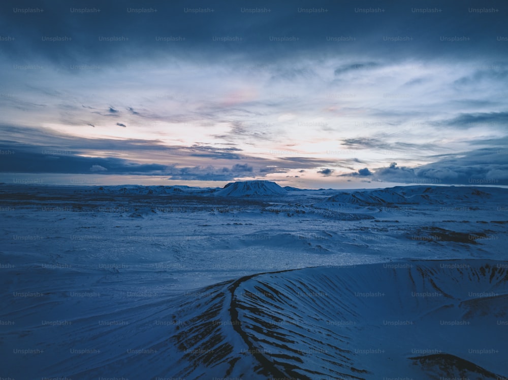 a snow covered landscape with mountains in the distance