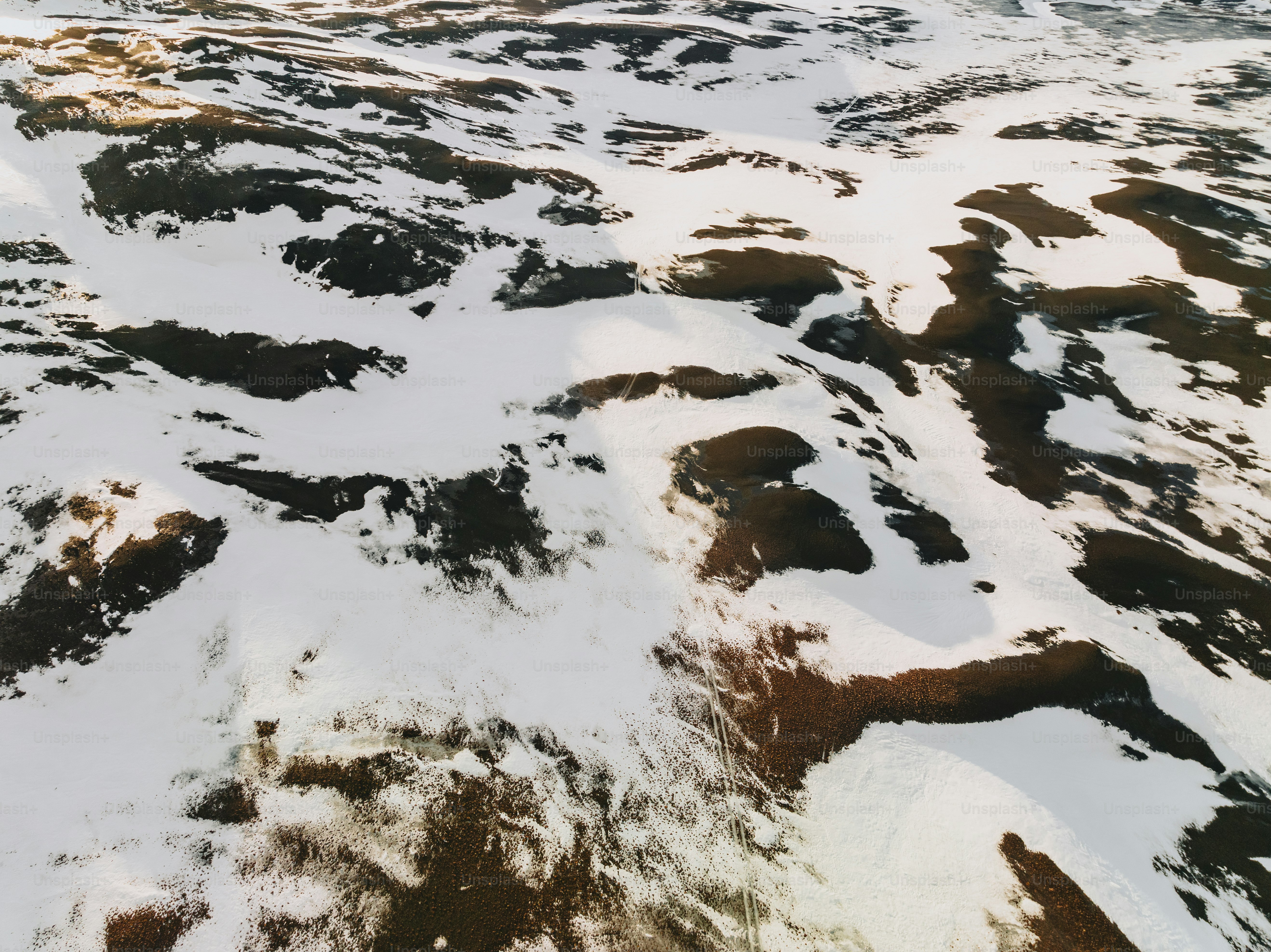 An aerial view of a snow covered mountain photo – Snow patches Image on ...