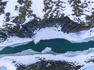 an aerial view of a lake surrounded by snow