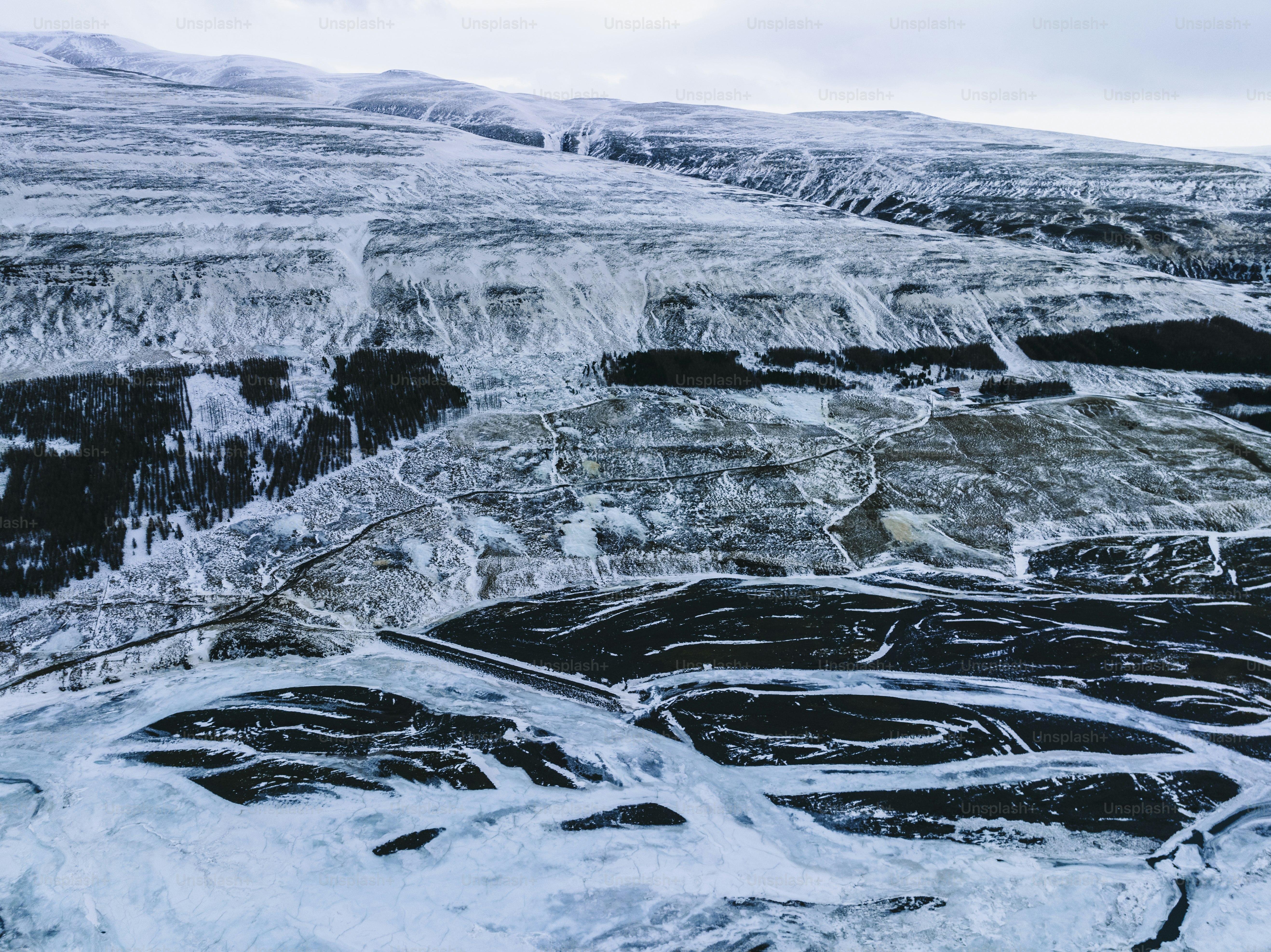 a snow covered landscape with a mountain in the background