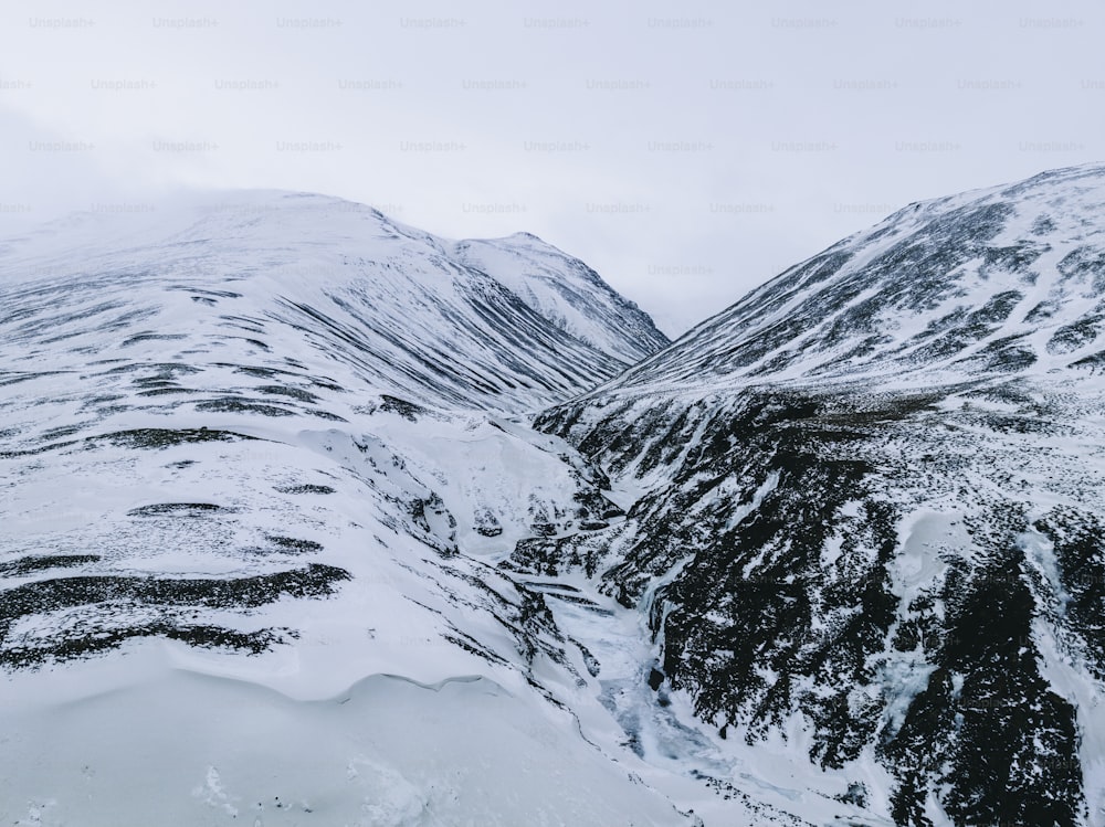 a snow covered mountain side with a sky background