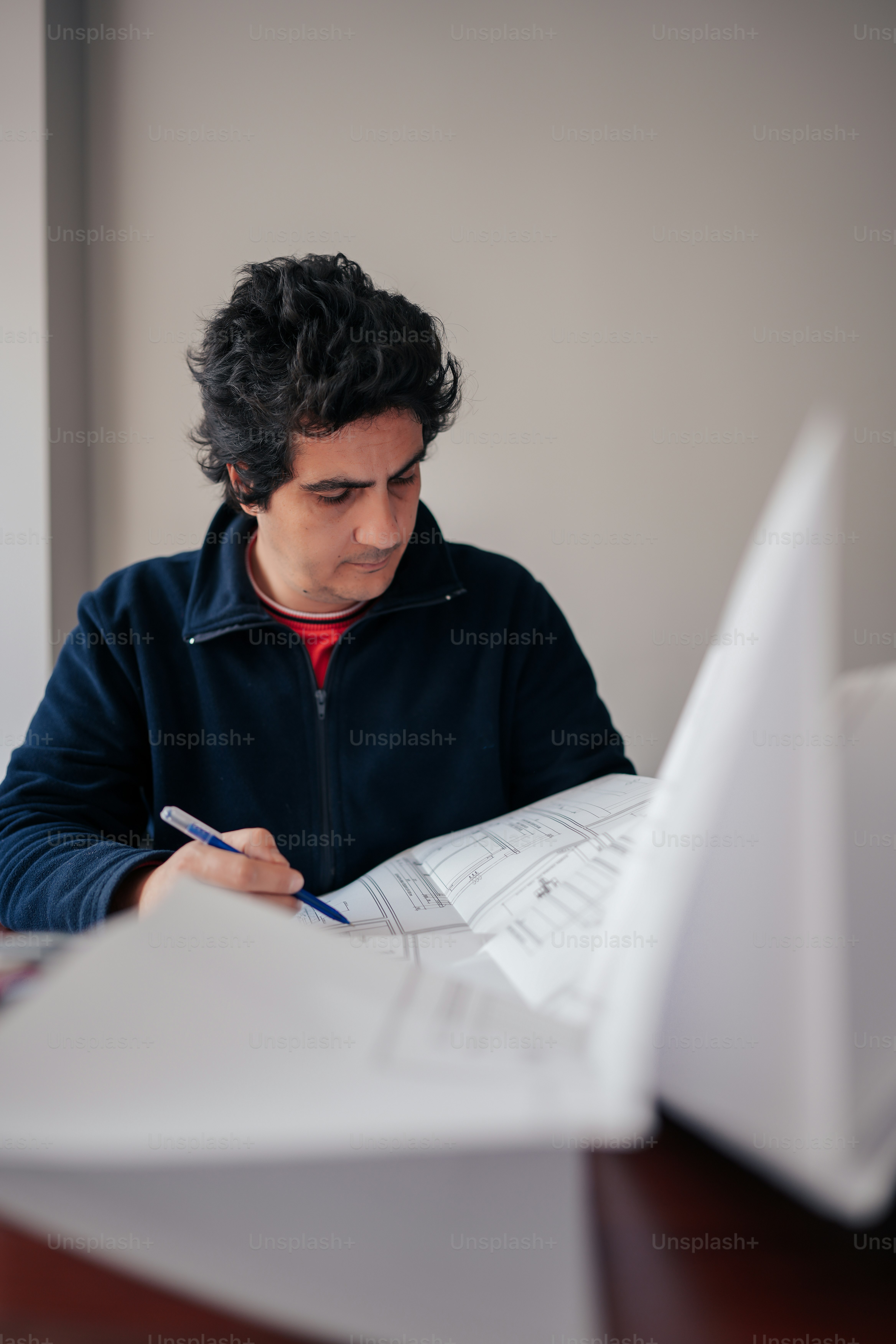 a man sitting at a desk writing on a piece of paper