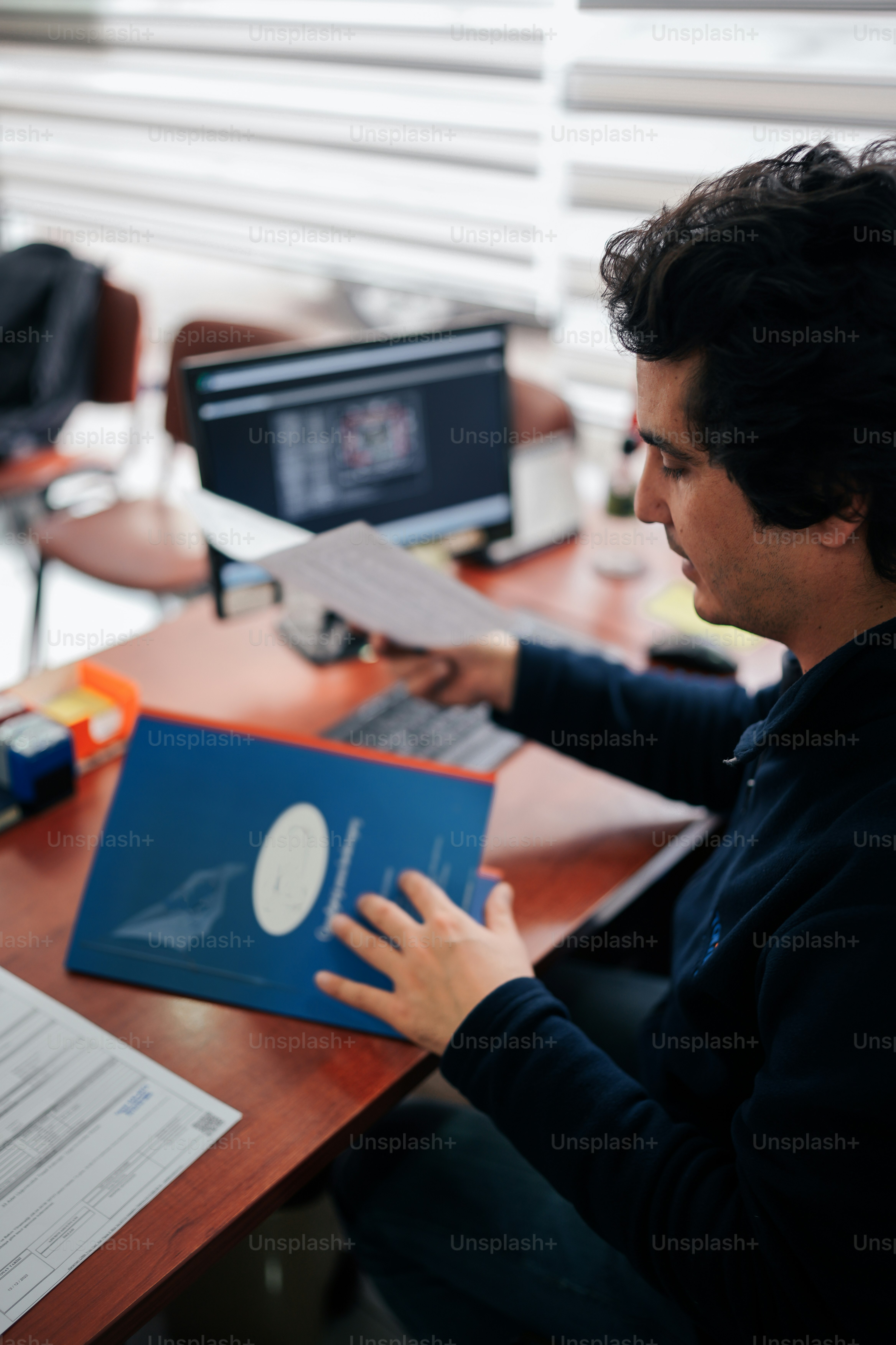 a man sitting at a desk using a laptop computer
