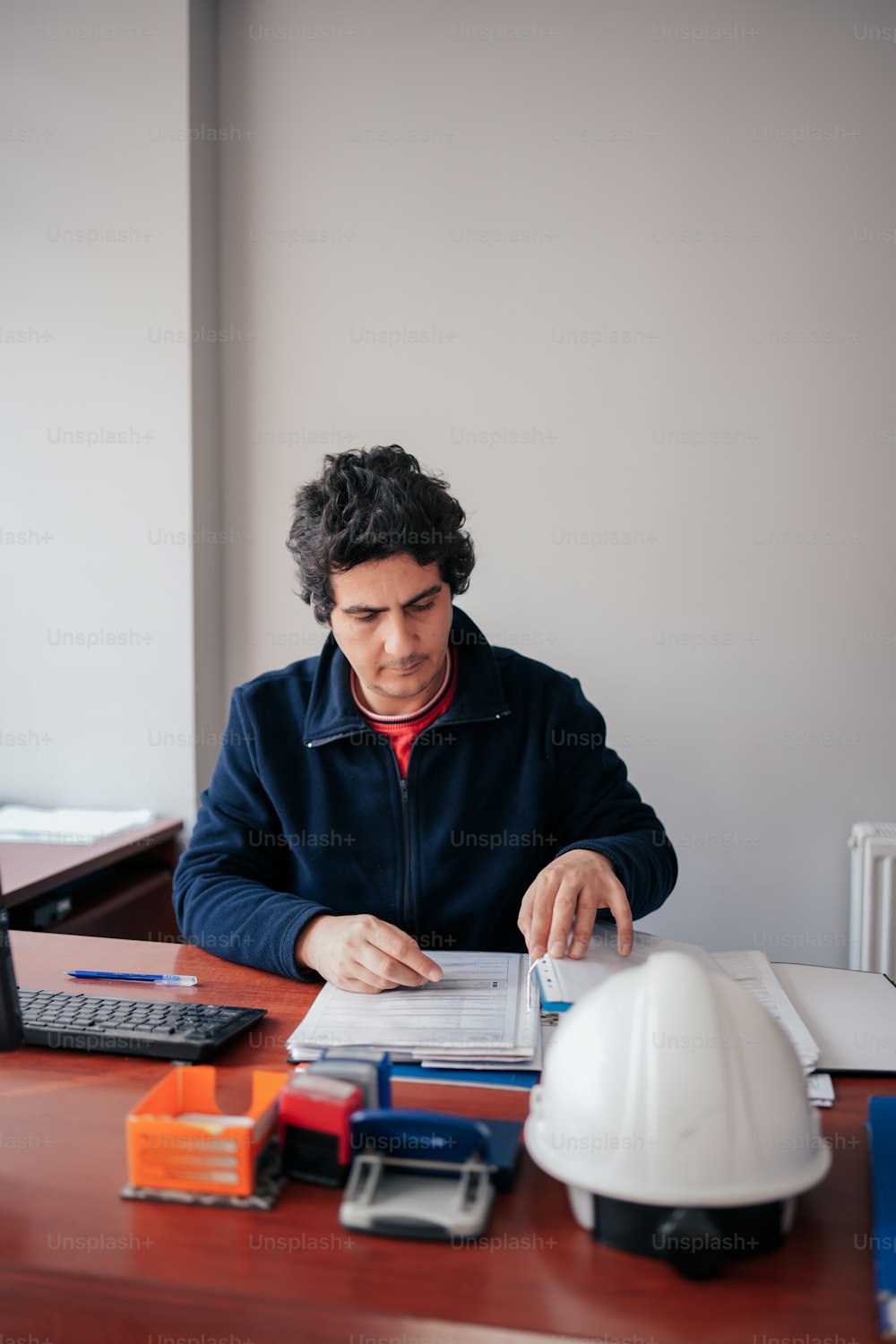 Ein Mann sitzt am Schreibtisch und arbeitet an einem Projekt