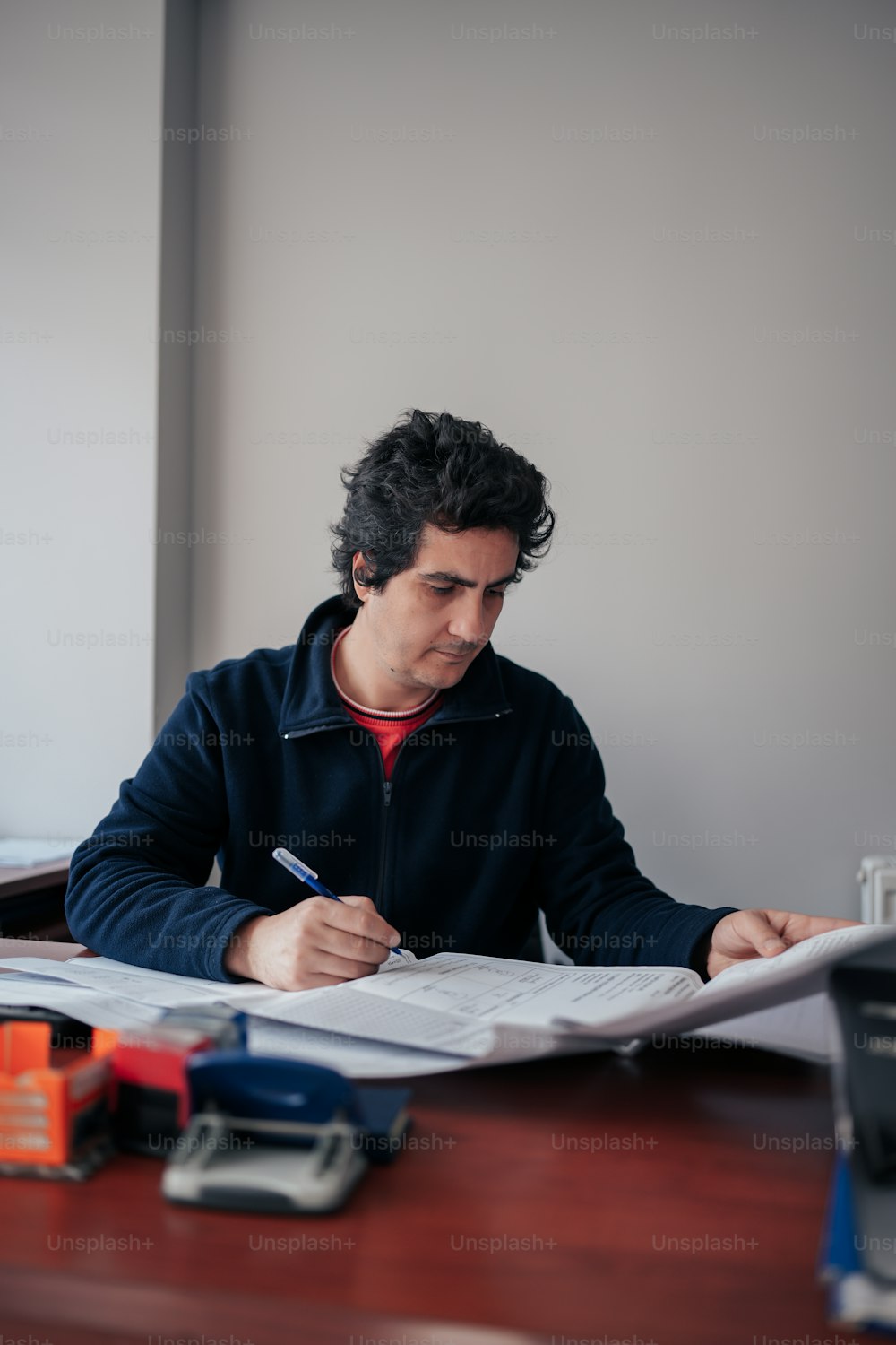 a man sitting at a desk writing on a piece of paper