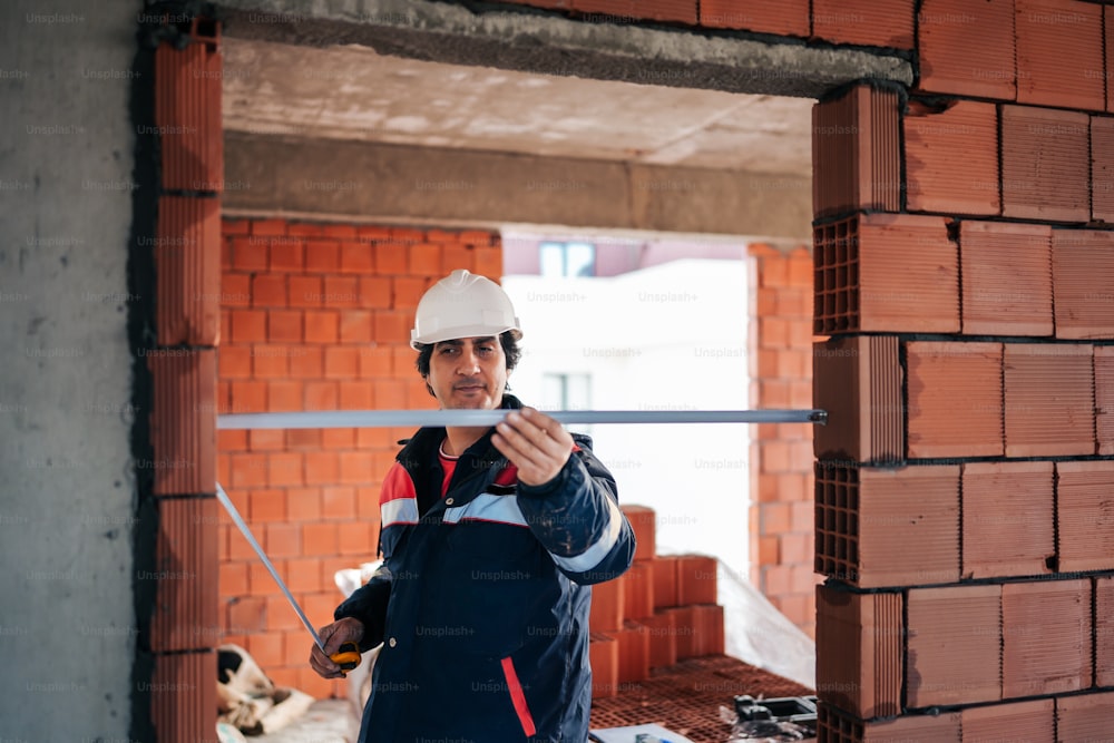 a man wearing a hard hat and holding a pipe