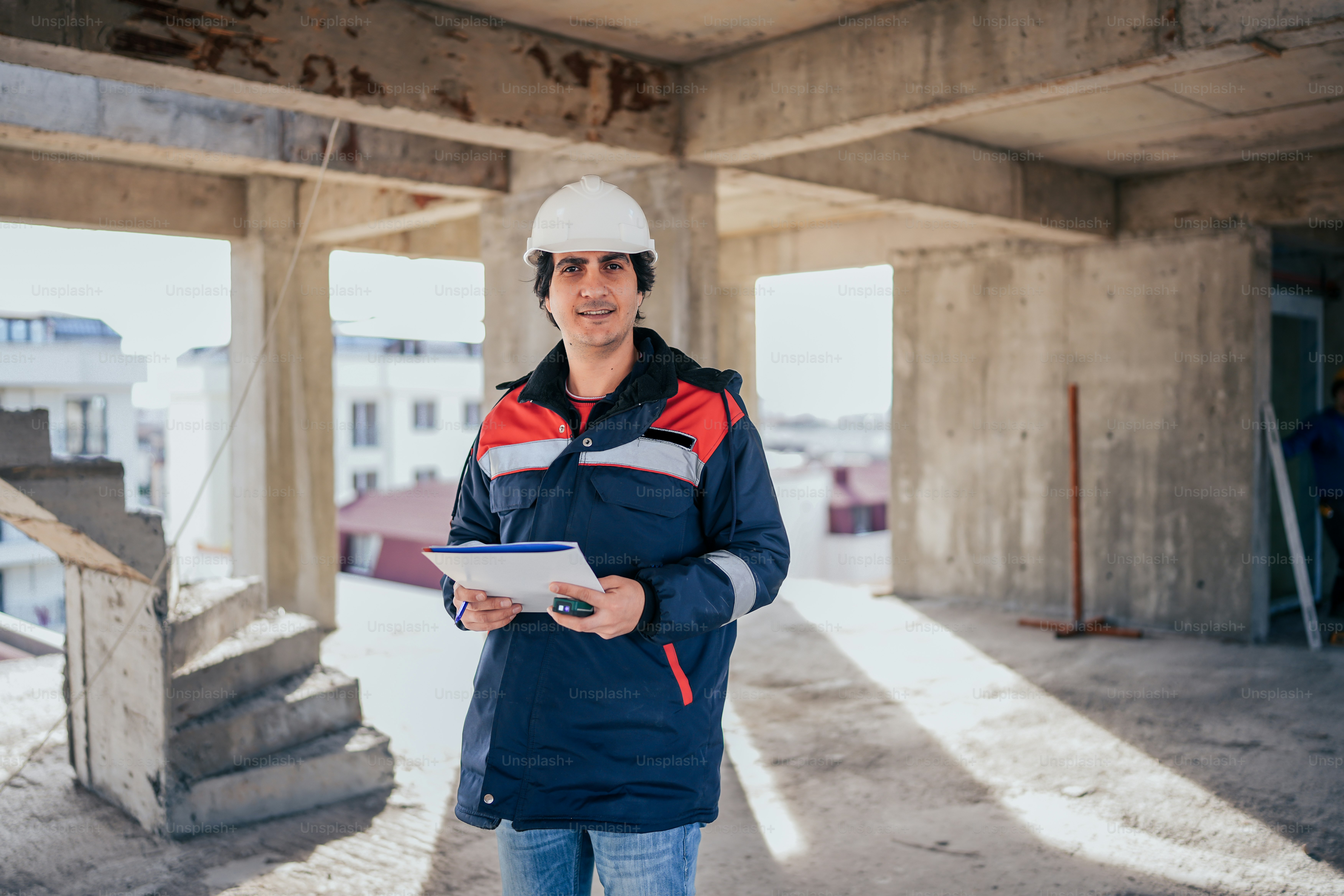 a man wearing a hard hat and holding a clipboard