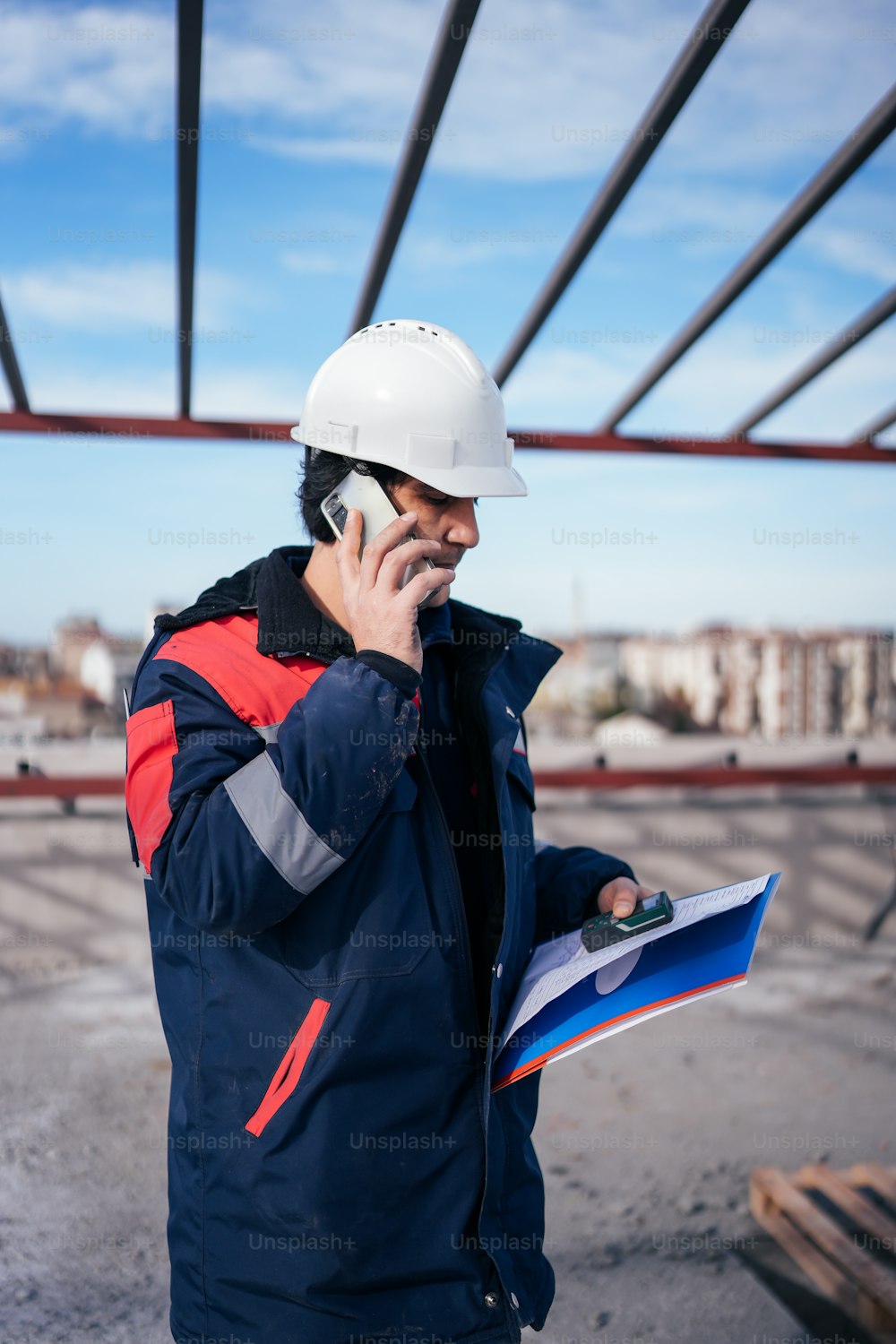 a man in a hard hat talking on a cell phone