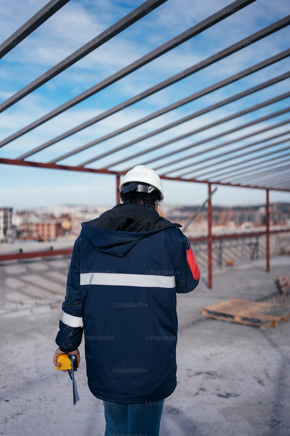 a man in a hard hat and blue jacket