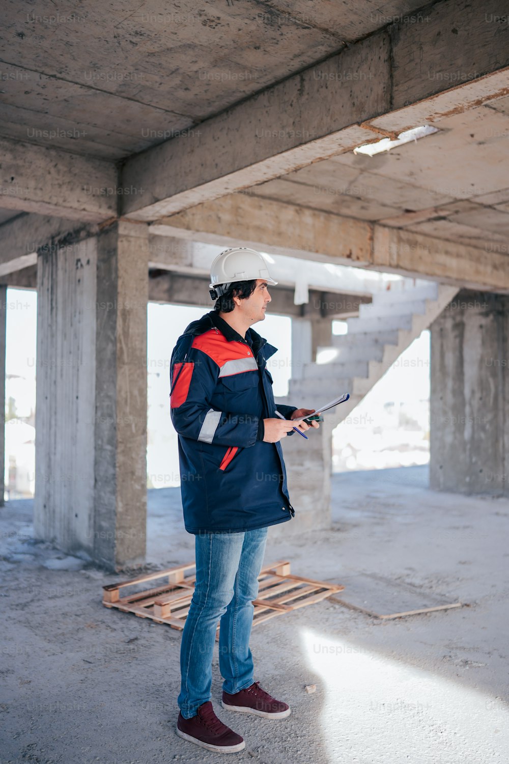 a woman wearing a hard hat standing in an unfinished building