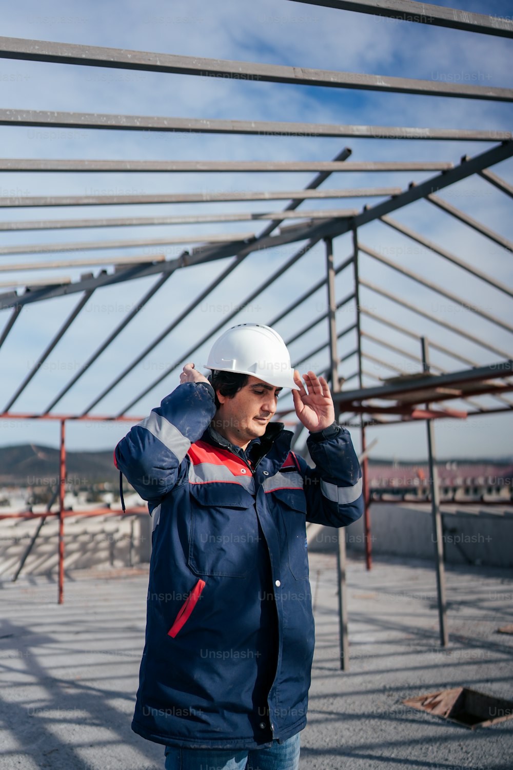 a man wearing a hard hat and blue jacket