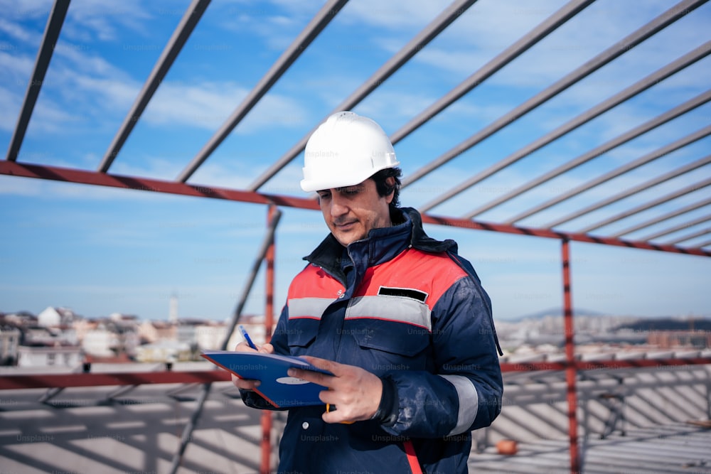 a man in a hard hat holding a clipboard
