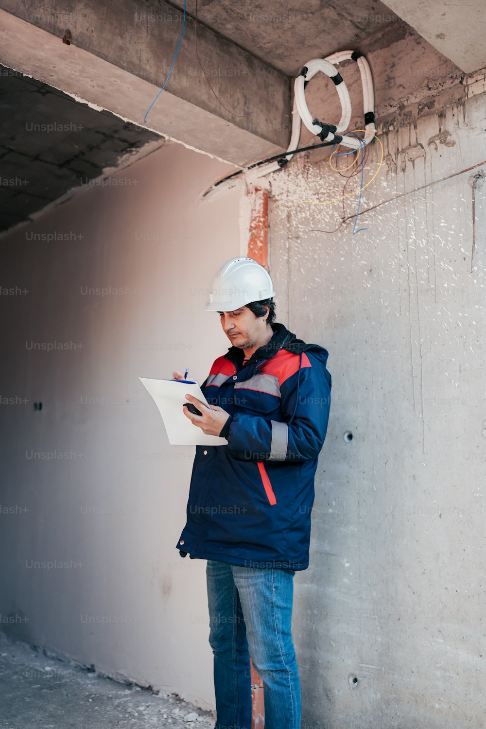 a man in a hard hat is writing on a piece of paper
