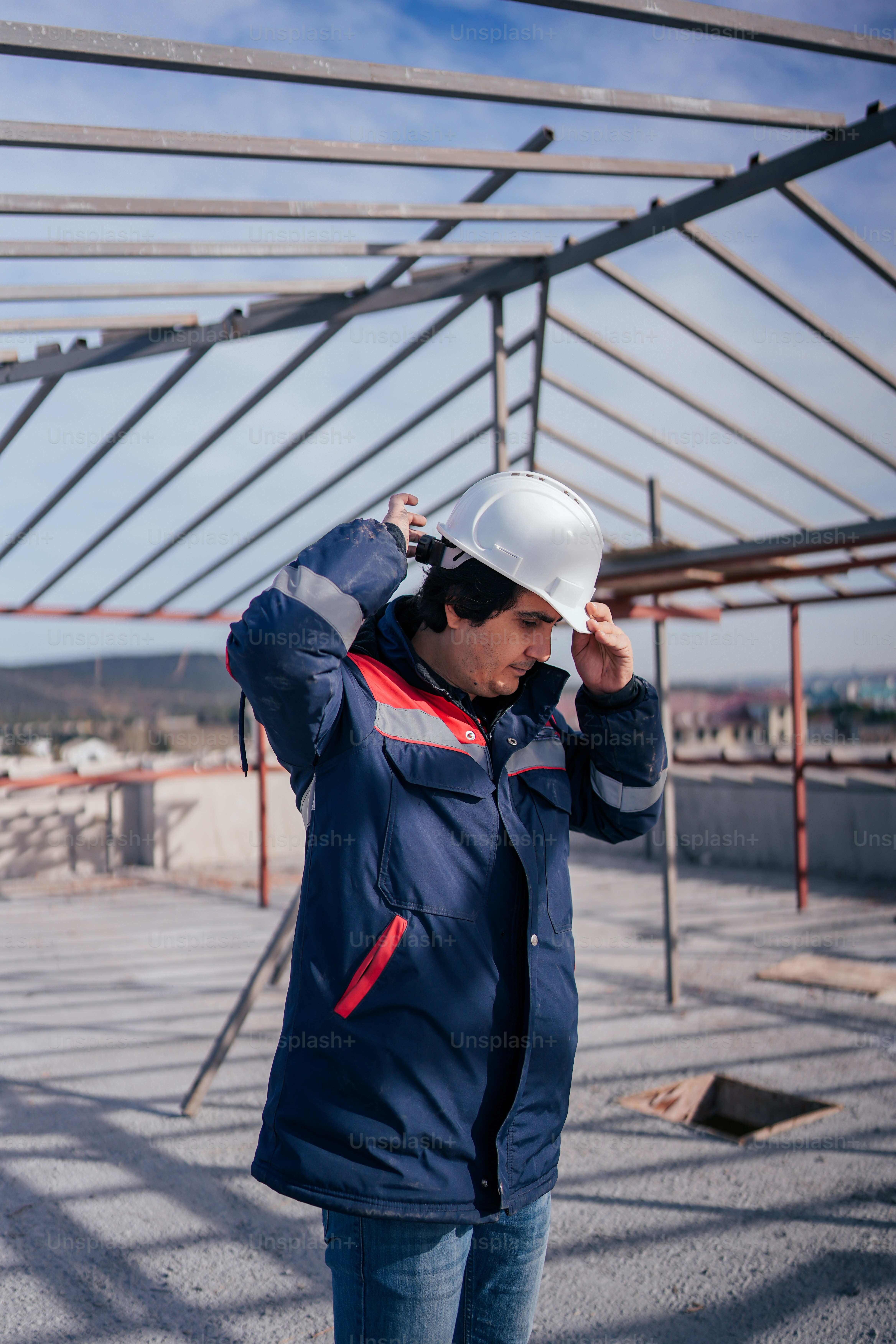 a man in a hard hat and blue jacket