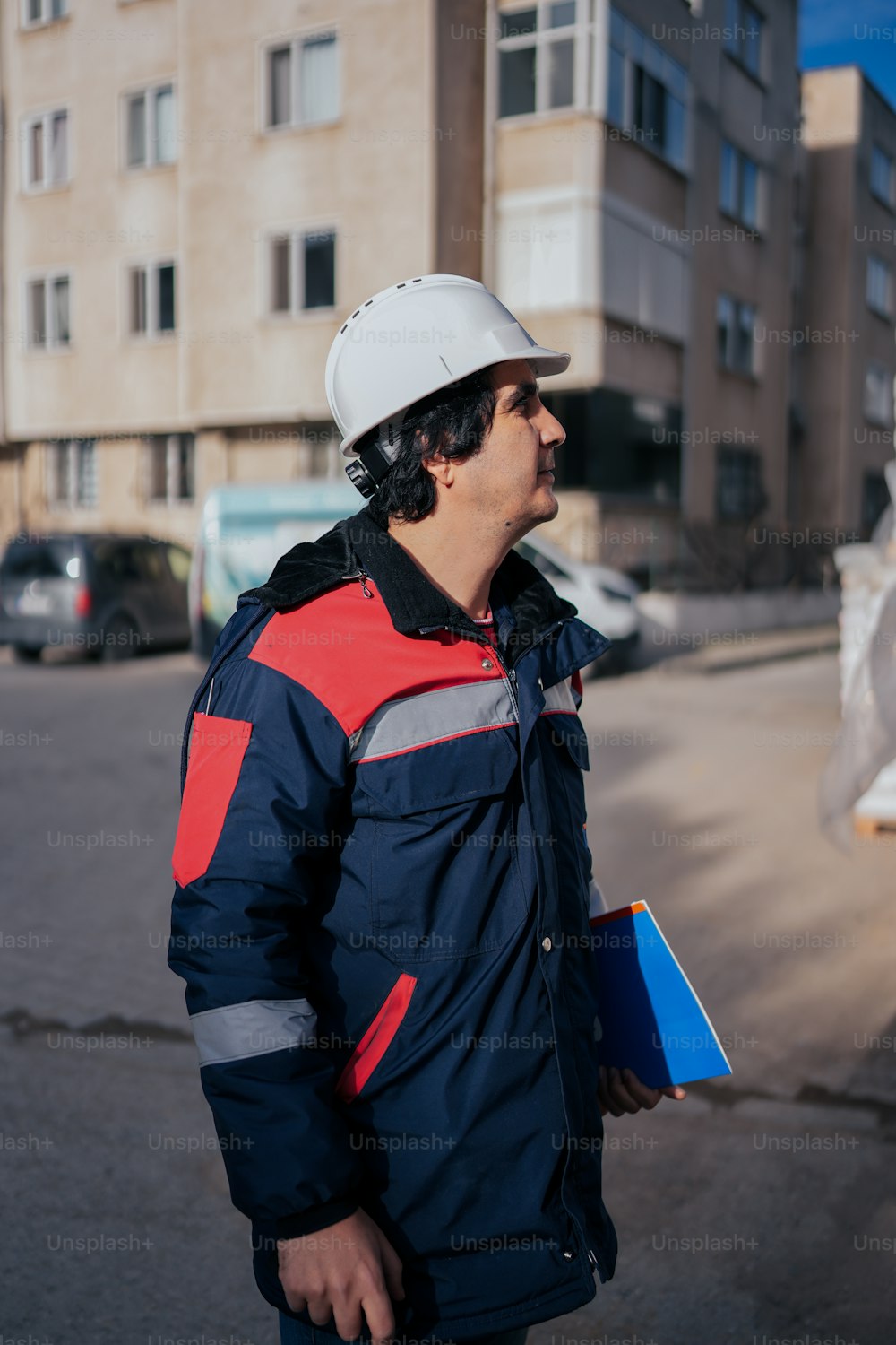 a man in a hard hat is standing on the street