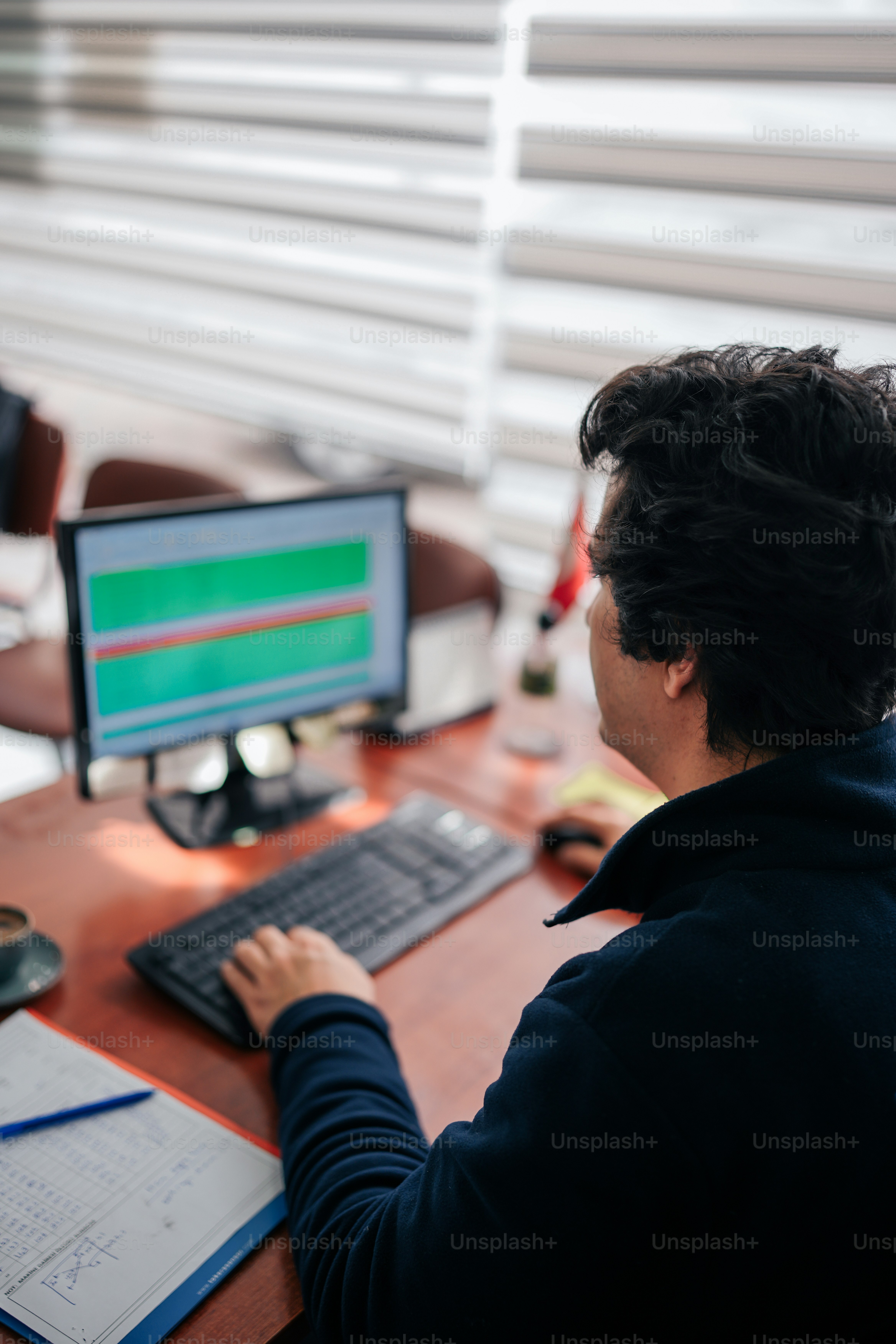 A person sitting at a desk with a computer photo – Professional Image ...