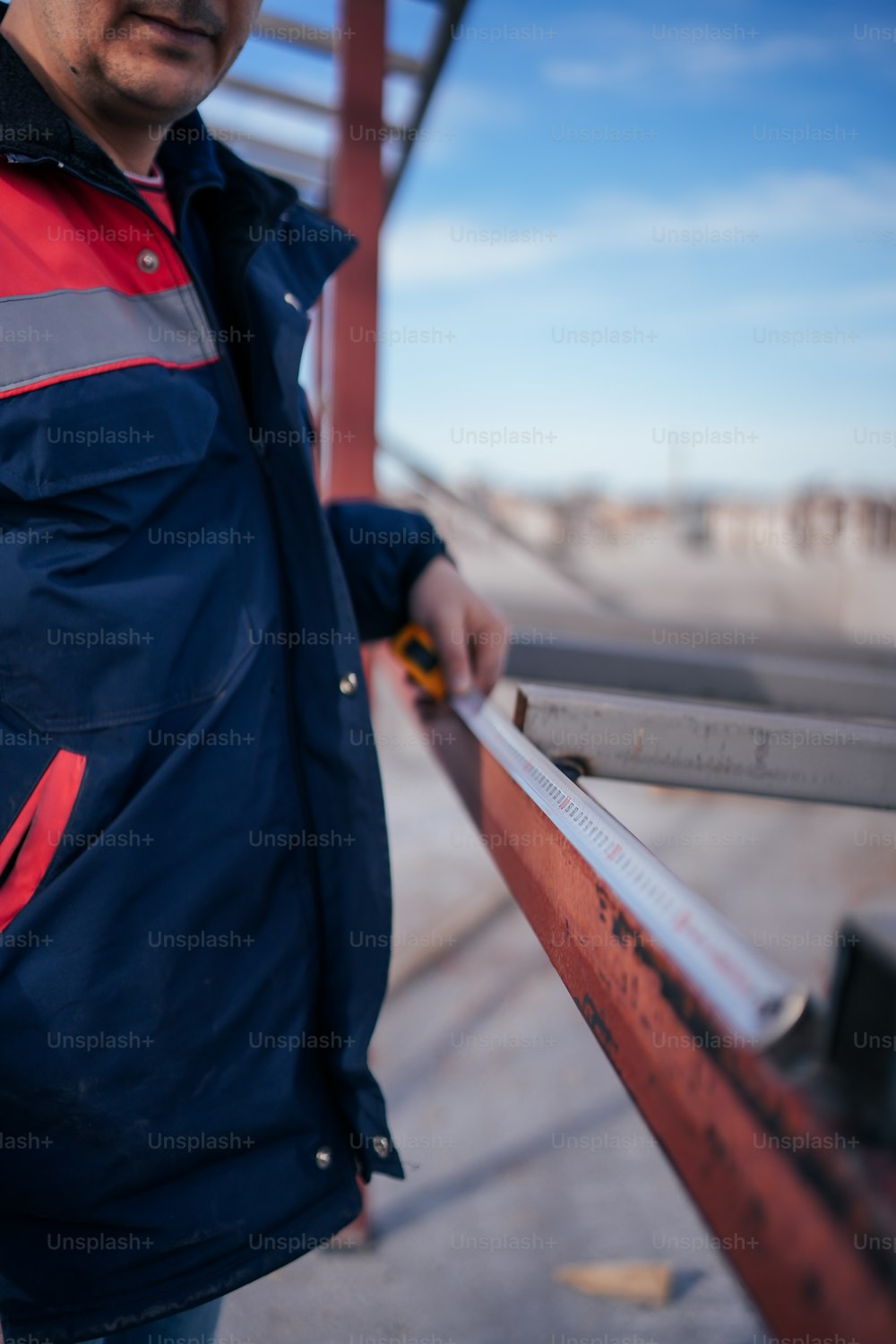 a man standing next to a rail holding a piece of wood