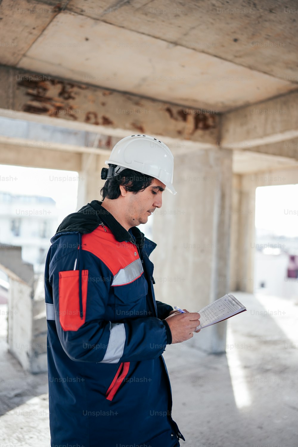 a man in a hard hat is reading a paper