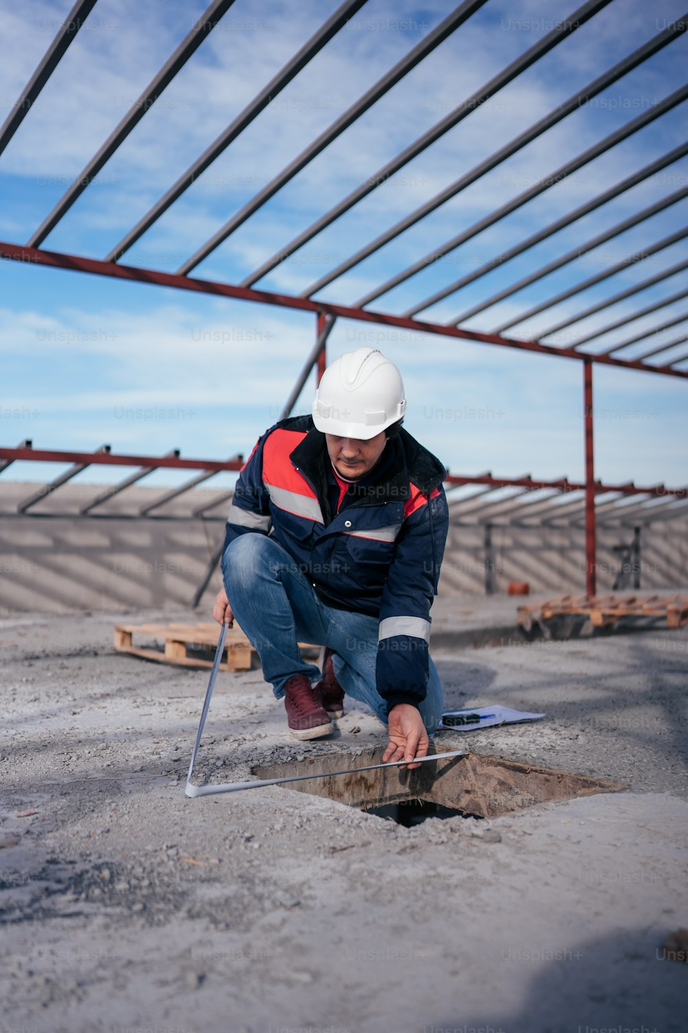 a man in a hard hat kneeling down on the ground