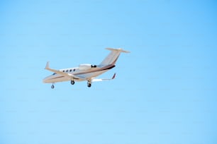 Ein kleines Flugzeug fliegt durch einen blauen Himmel