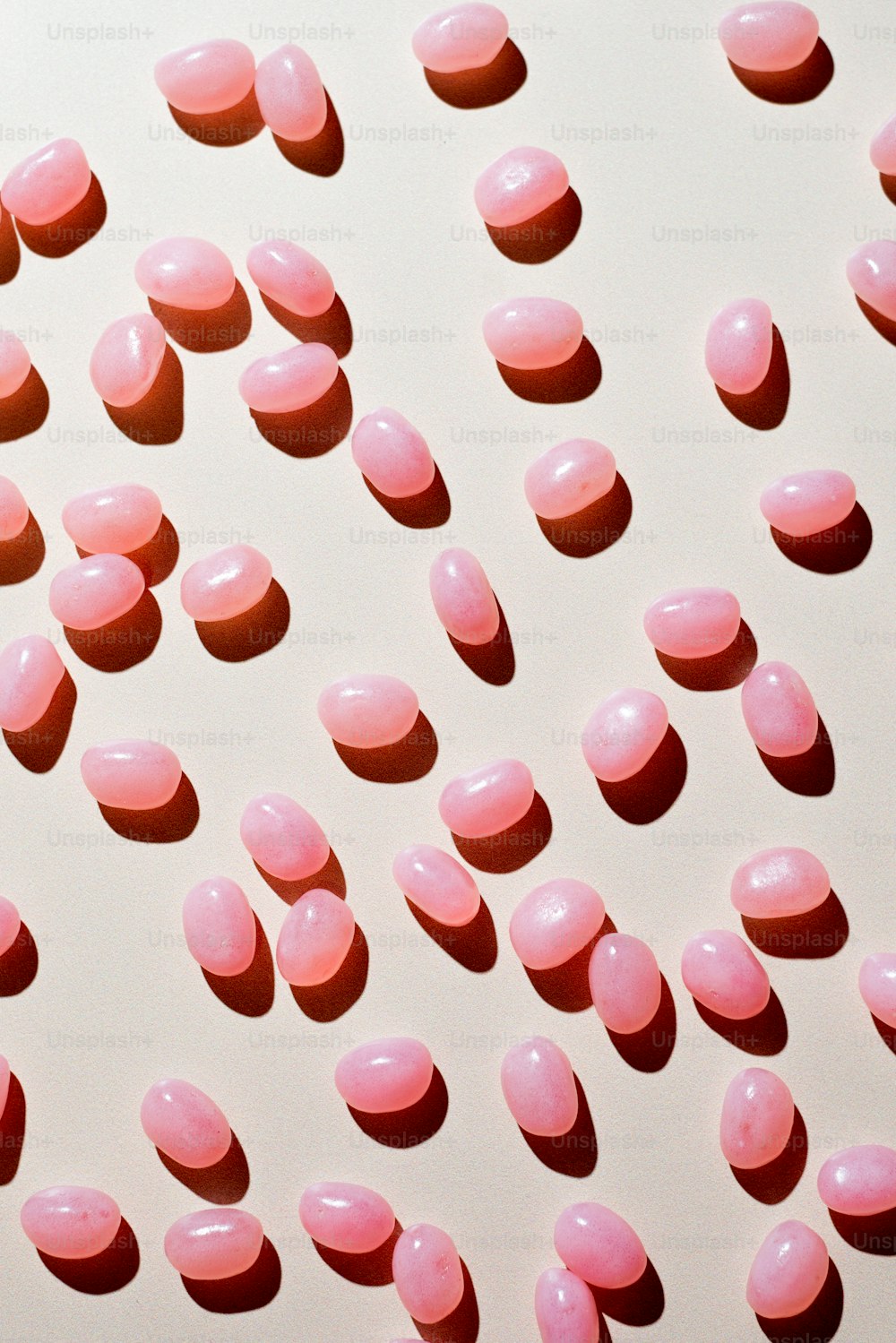 um monte de pílulas cor-de-rosa em uma superfície branca