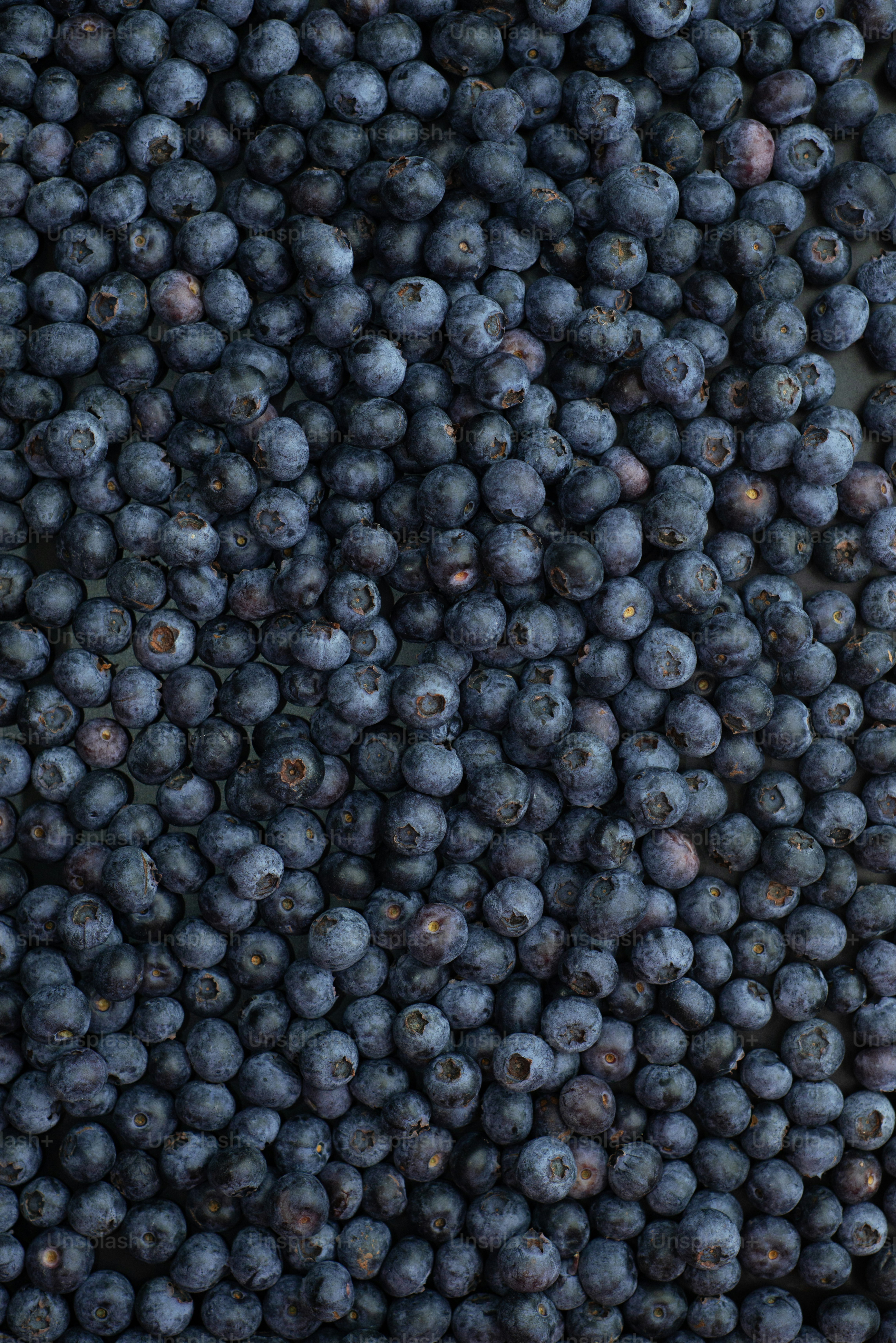 a bunch of blueberries are piled on top of each other