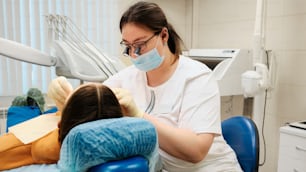 患者と一緒に歯科医の椅子に座っている女性
