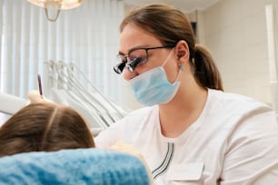 a woman in a dentist's chair wearing a face mask