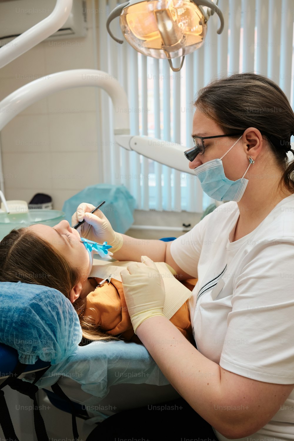 a woman getting her teeth checked by a dentist