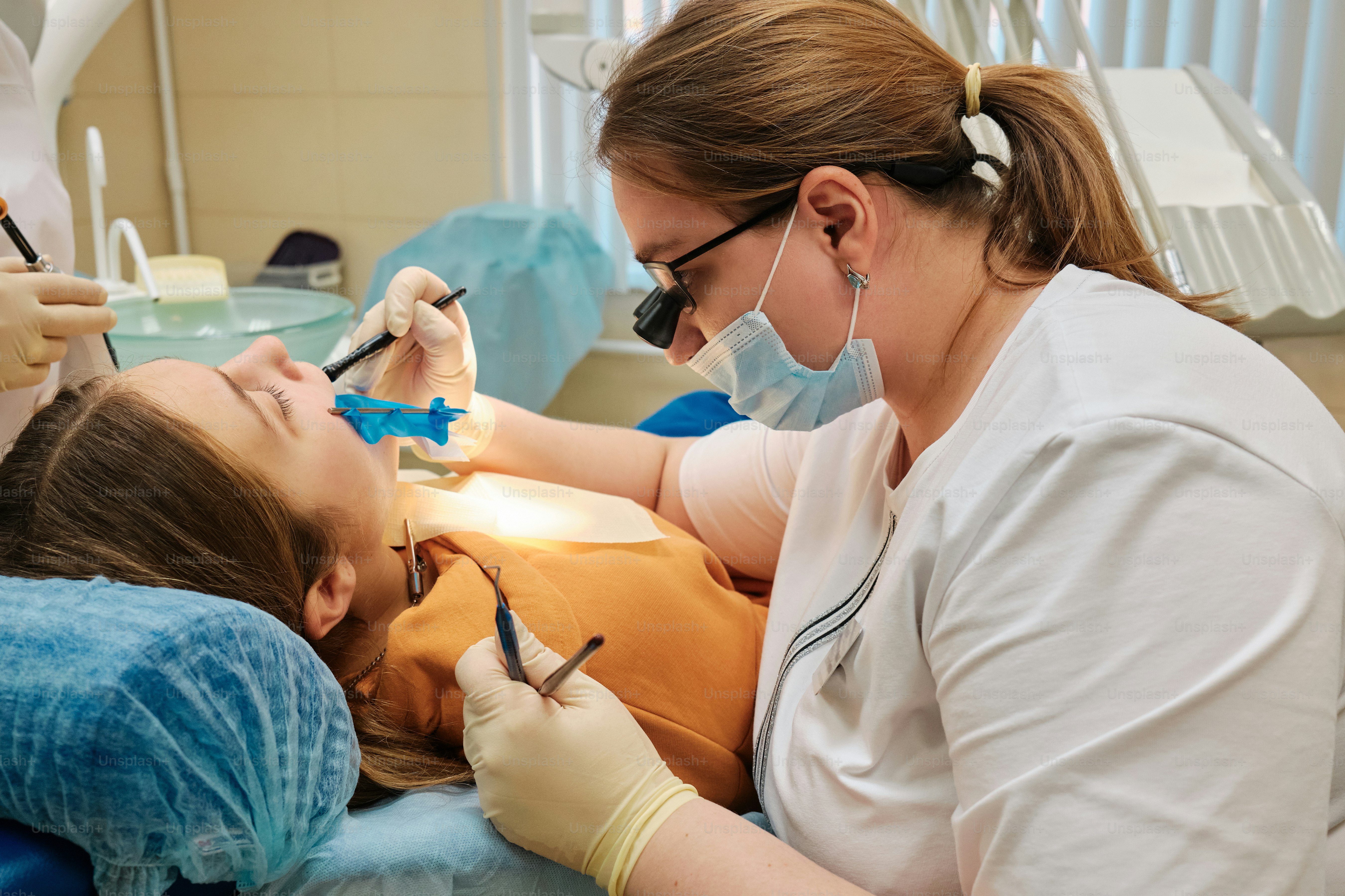 a woman getting her teeth checked by a dentist