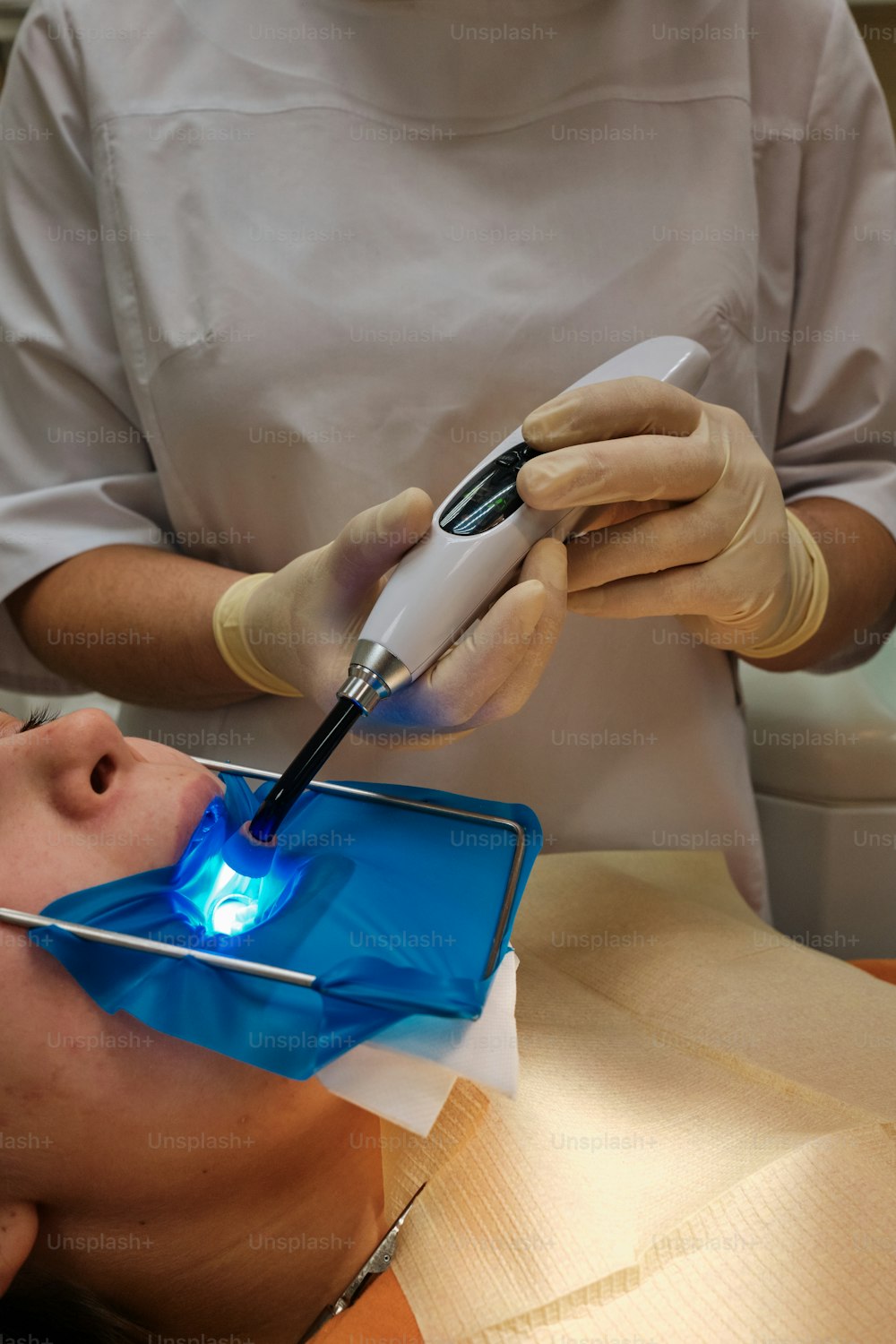 Eine Person auf einem Zahnarztstuhl mit eingeschaltetem Licht