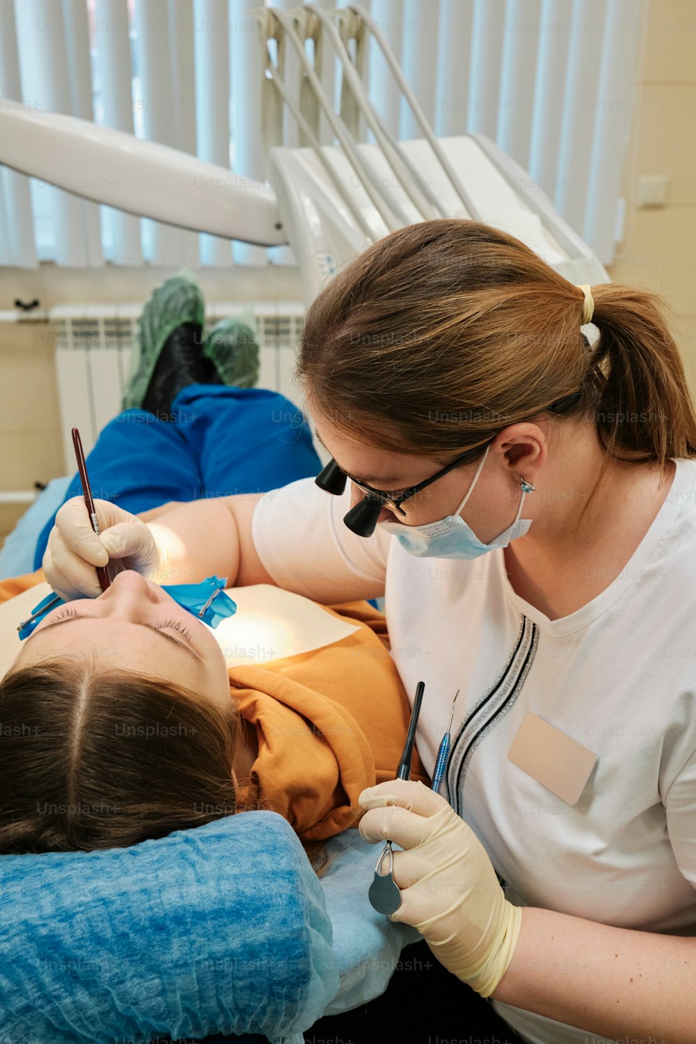 uma mulher na cadeira de um dentista que verifica os dentes