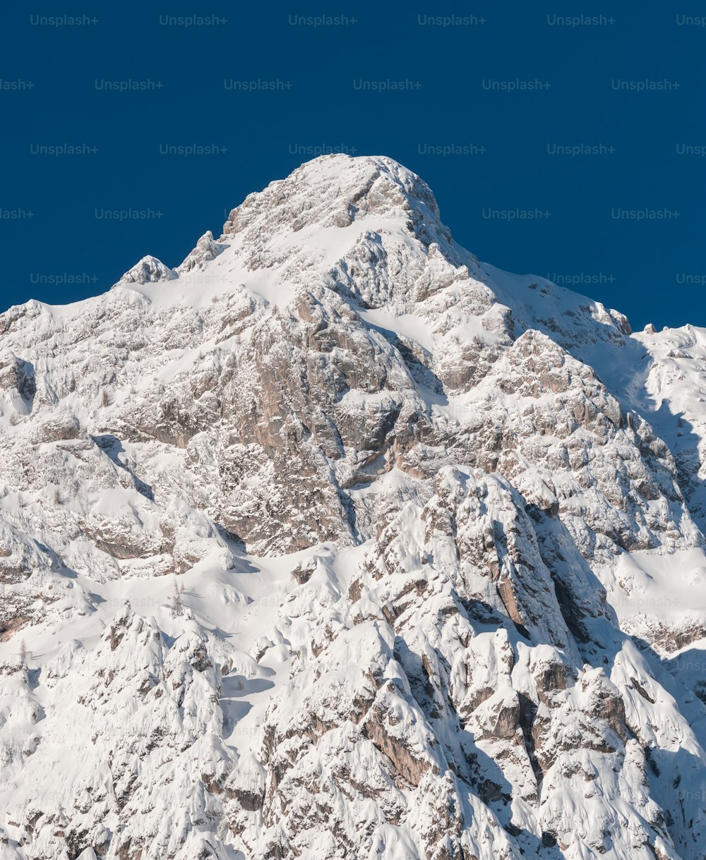 uma grande montanha coberta de neve sob um céu azul