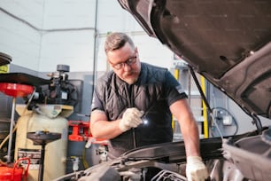 Un homme travaillant sur un moteur de voiture dans un garage