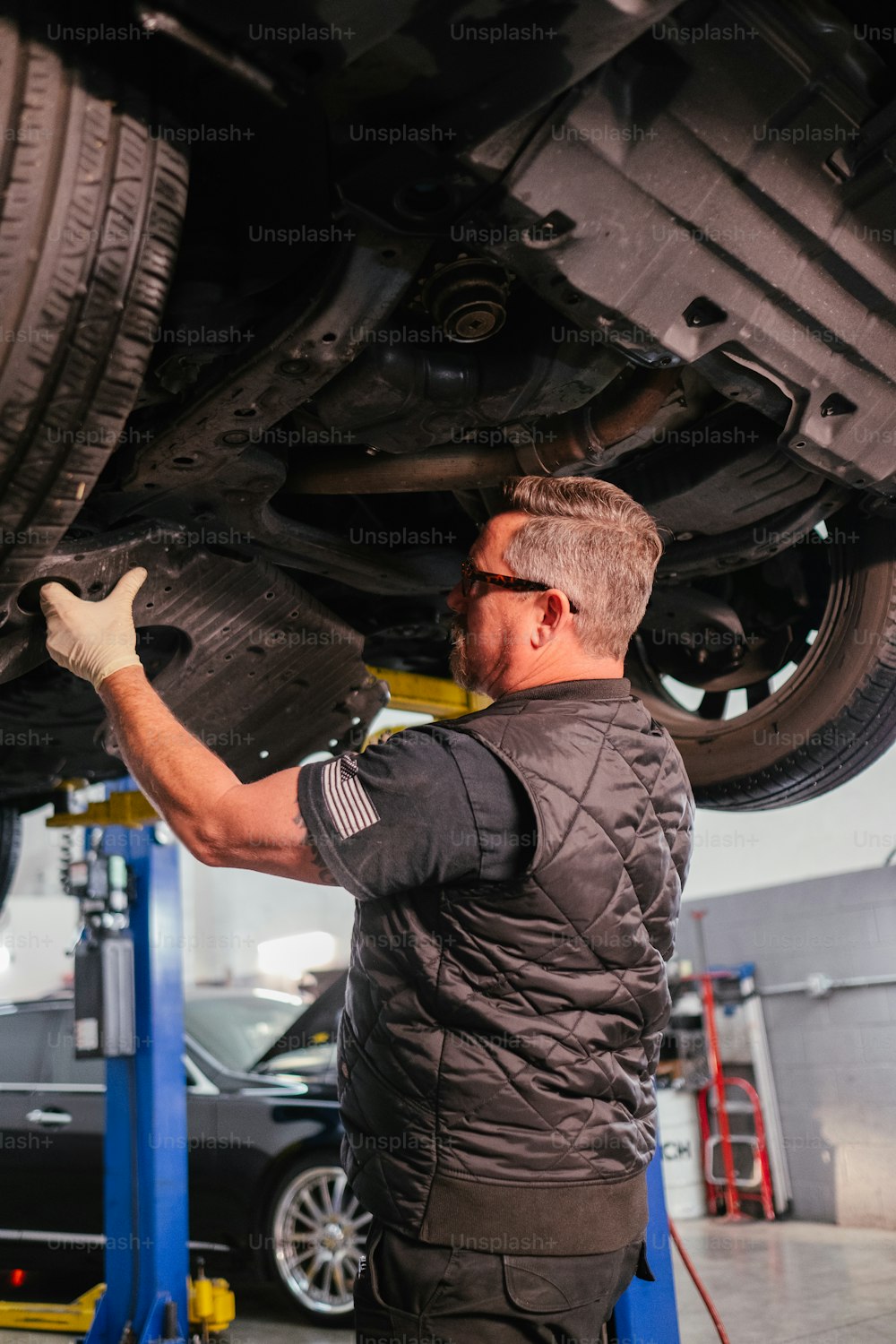 um homem que trabalha em um carro em uma garagem