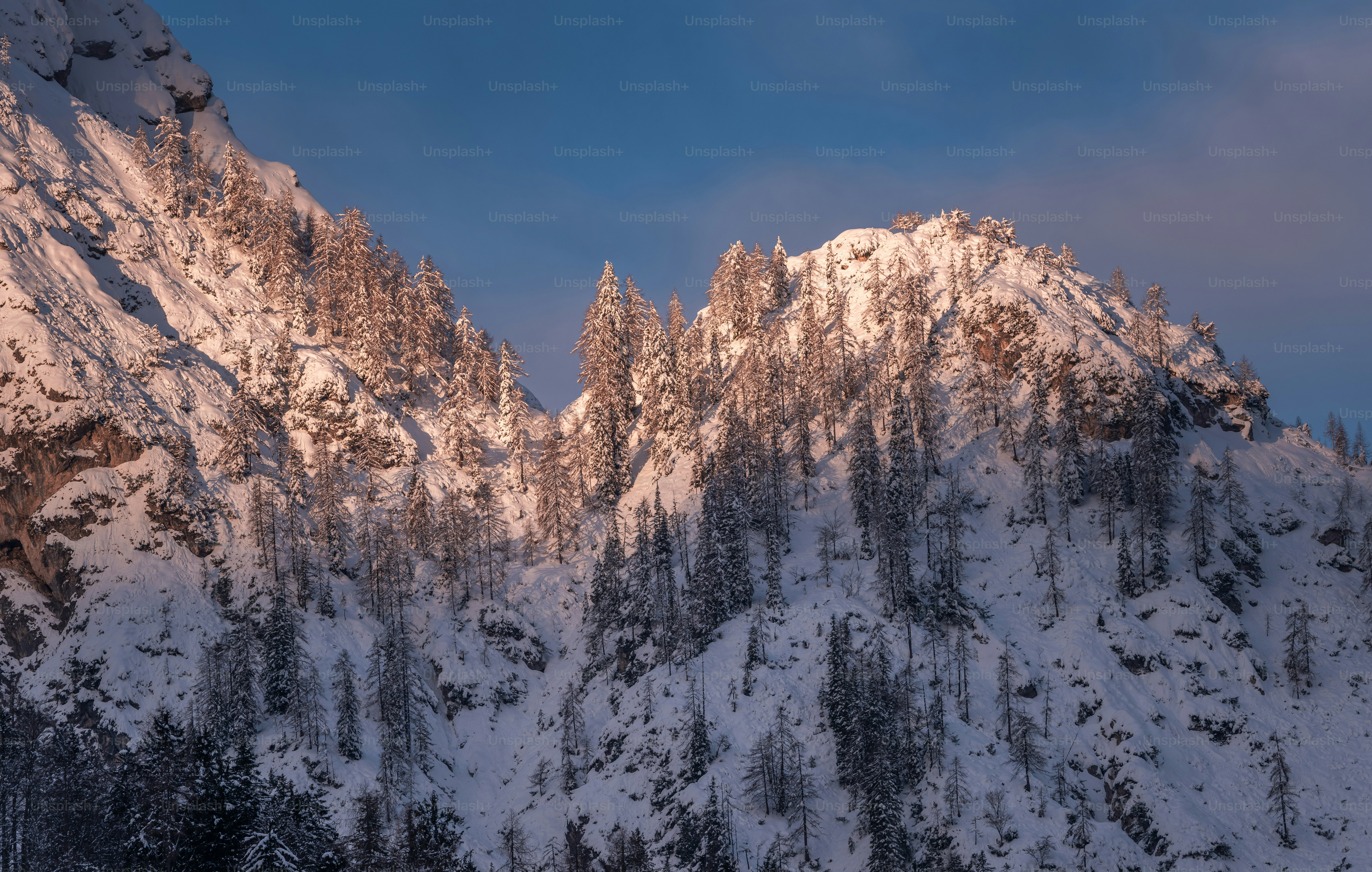 A large mountain covered in snow under a blue sky photo – White ...