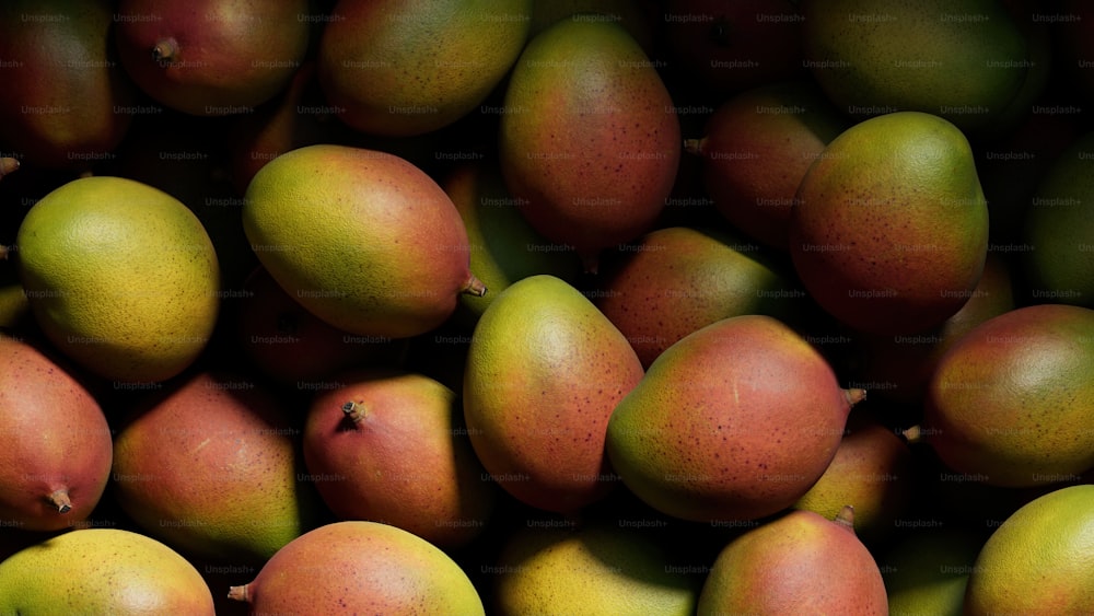 a close up of a pile of mangoes