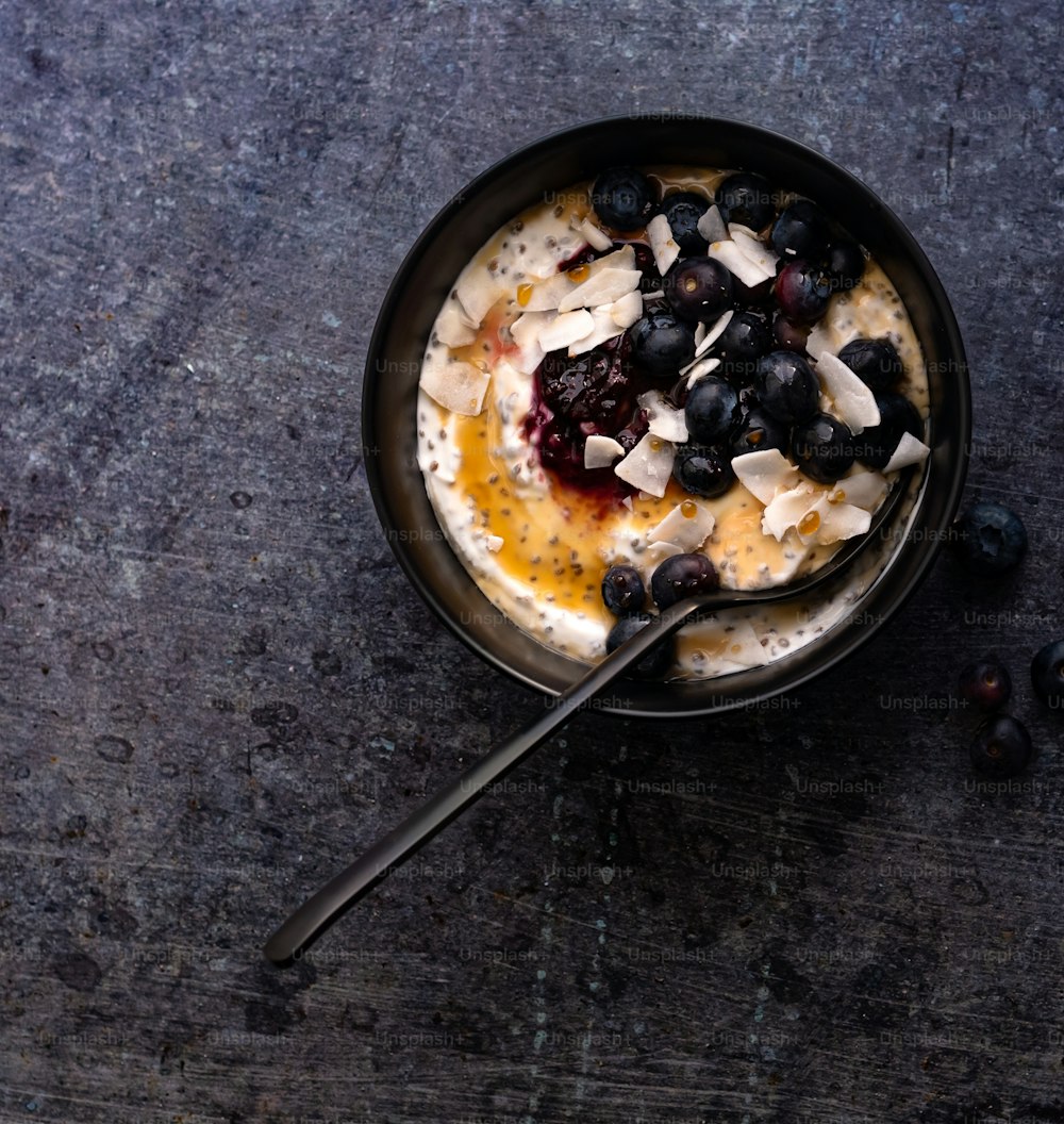 a bowl of oatmeal with blueberries and a spoon
