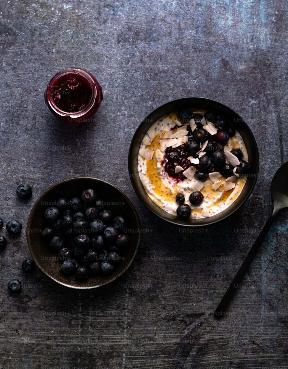 a bowl of oatmeal with blueberries and a spoon