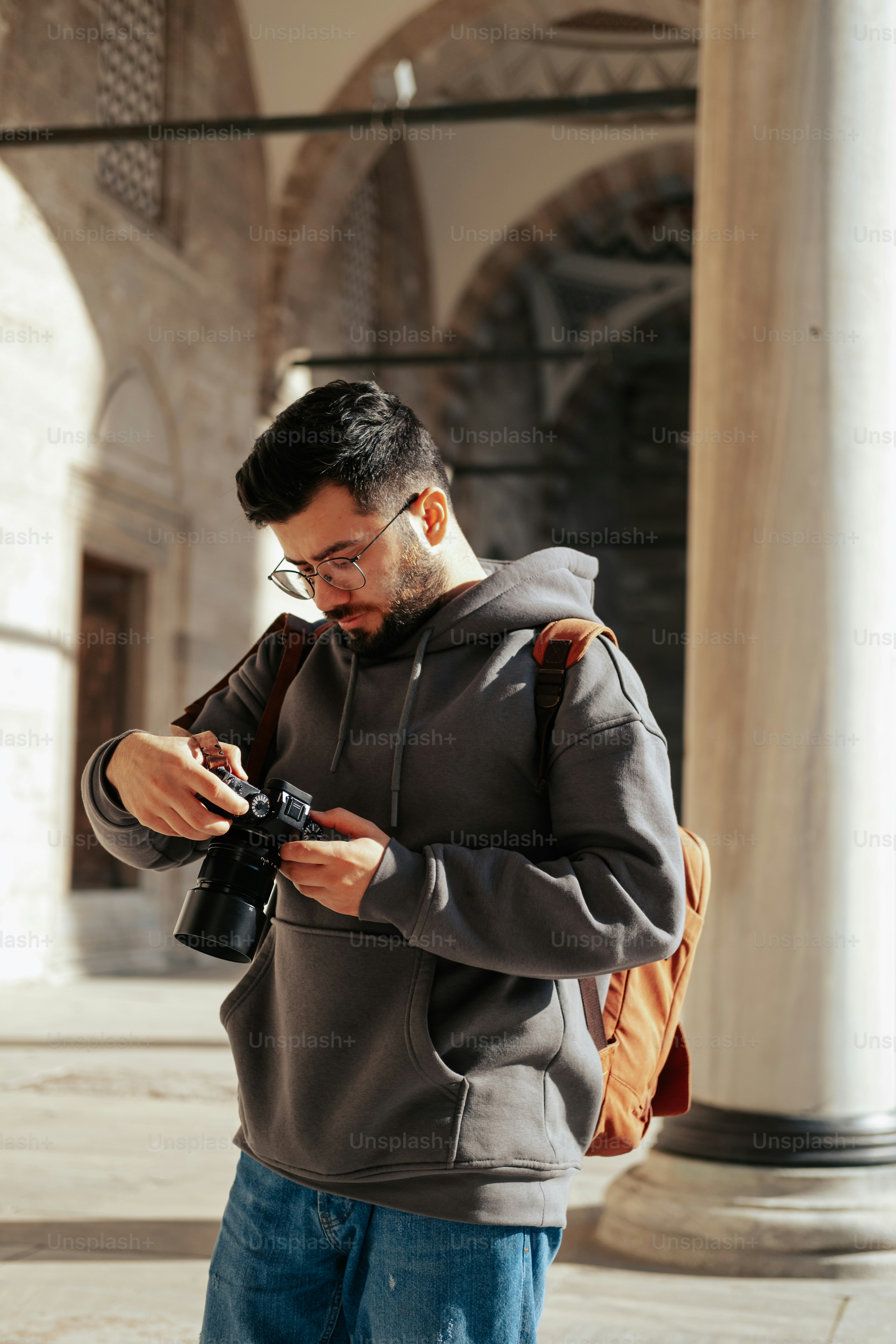 a man standing in a building looking at his cell phone