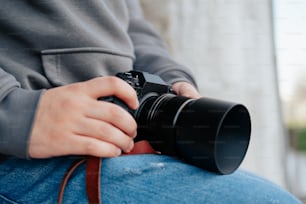 una persona seduta con in mano una macchina fotografica