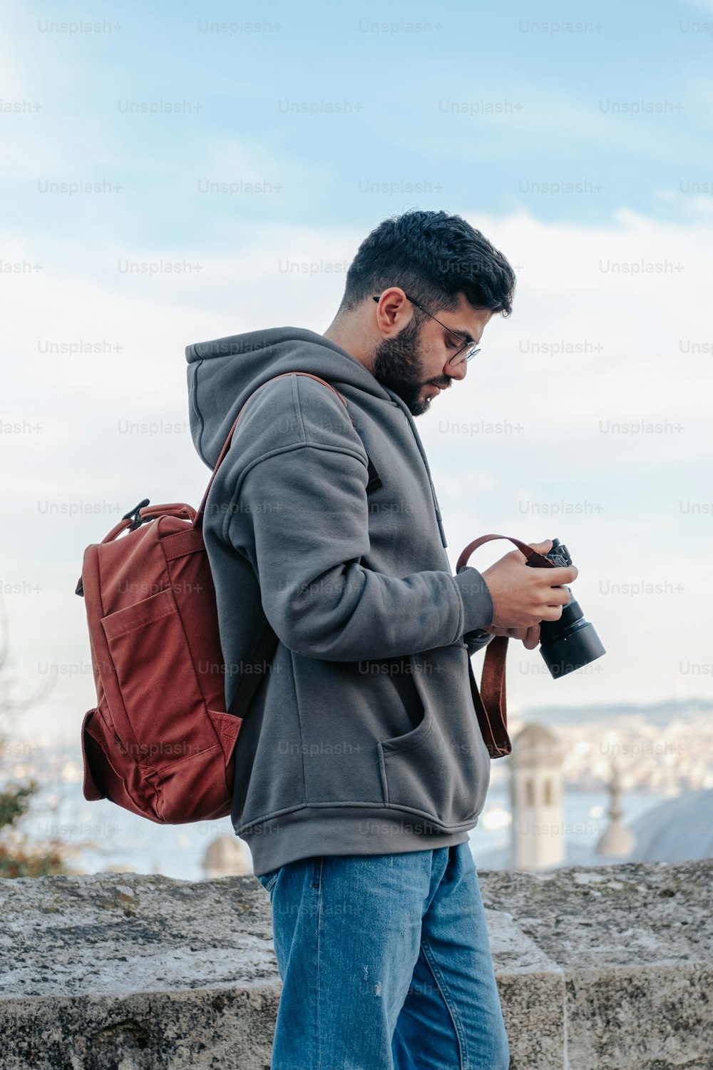 Ein Mann mit Rucksack schaut auf sein Handy
