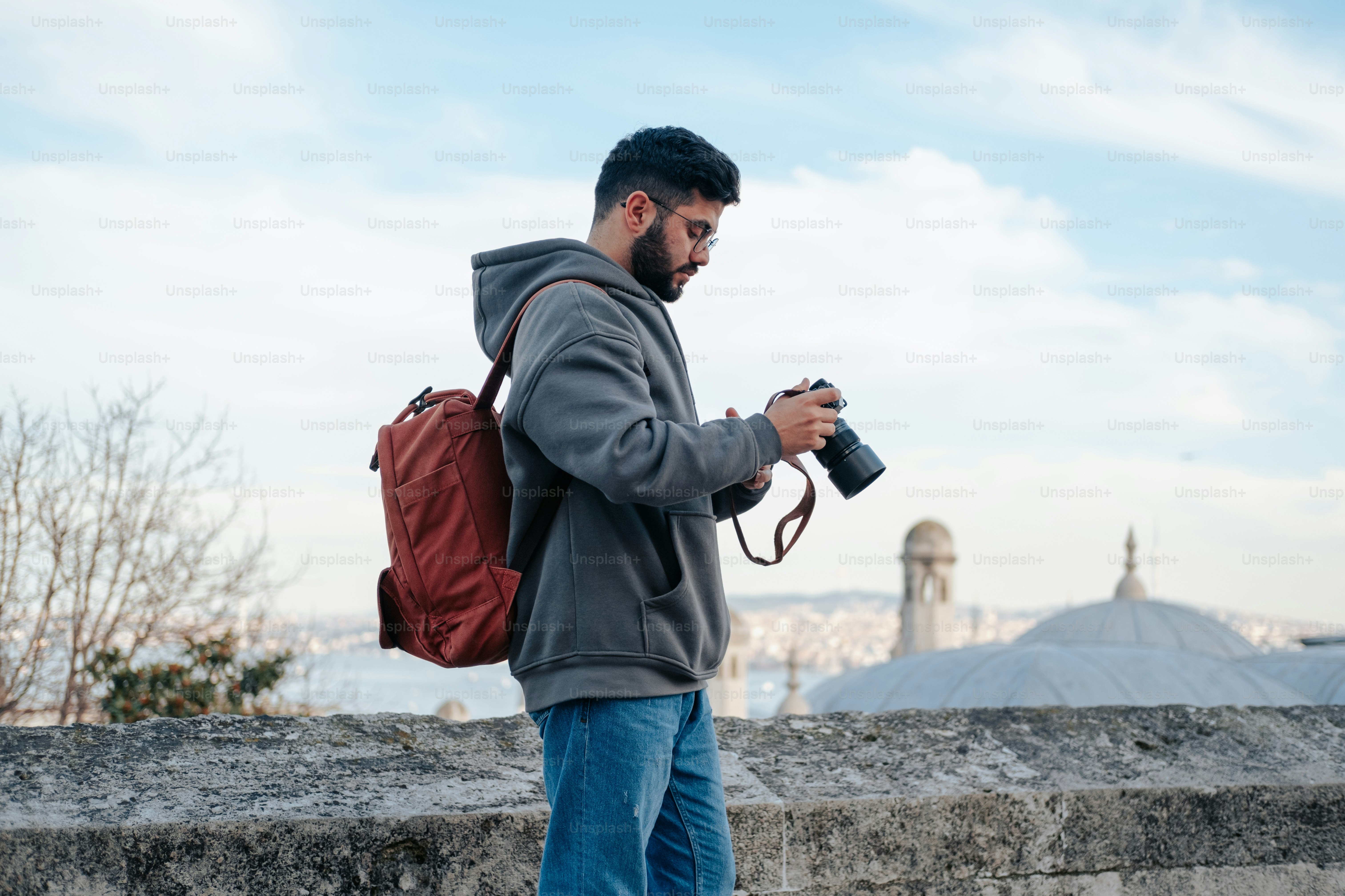 a man with a backpack looking at his cell phone