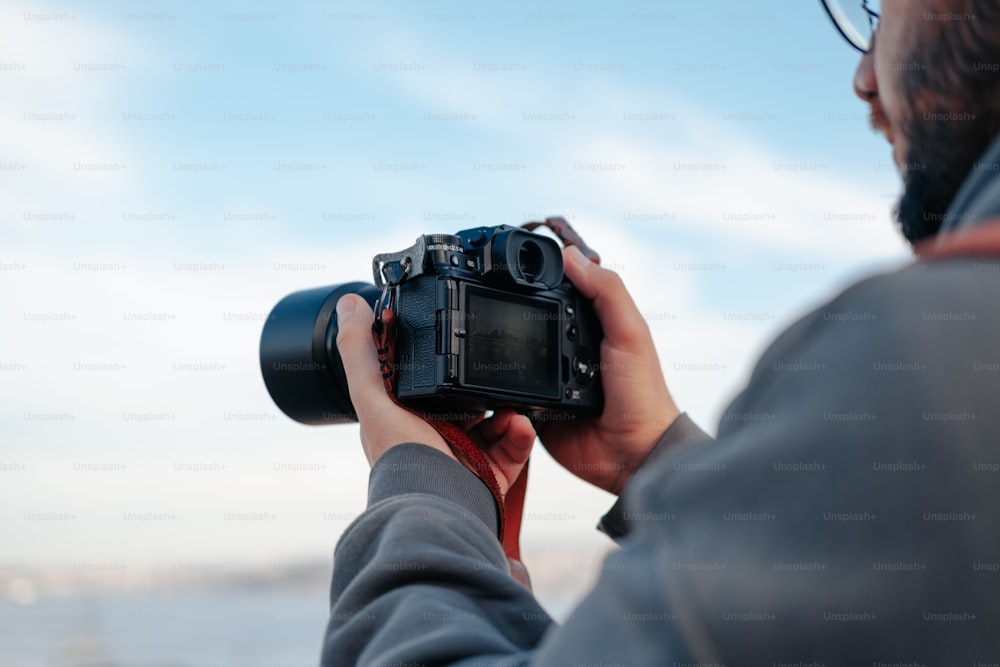 Un hombre sosteniendo una cámara para tomar una foto