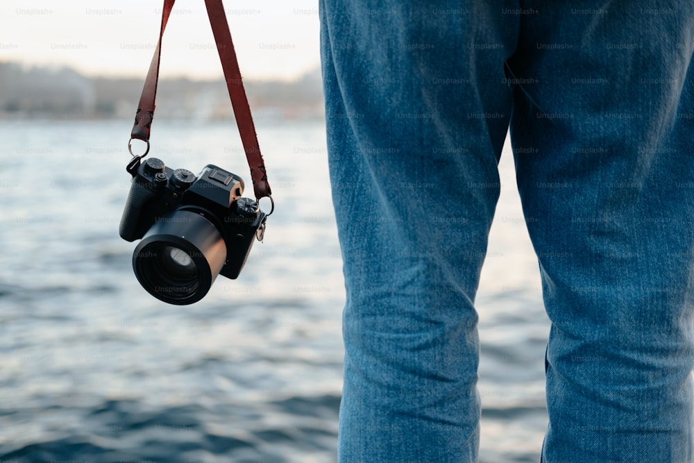 a person holding a camera and a camera strap