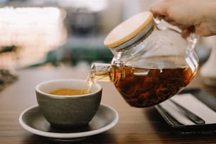 Una persona vierte té en una taza